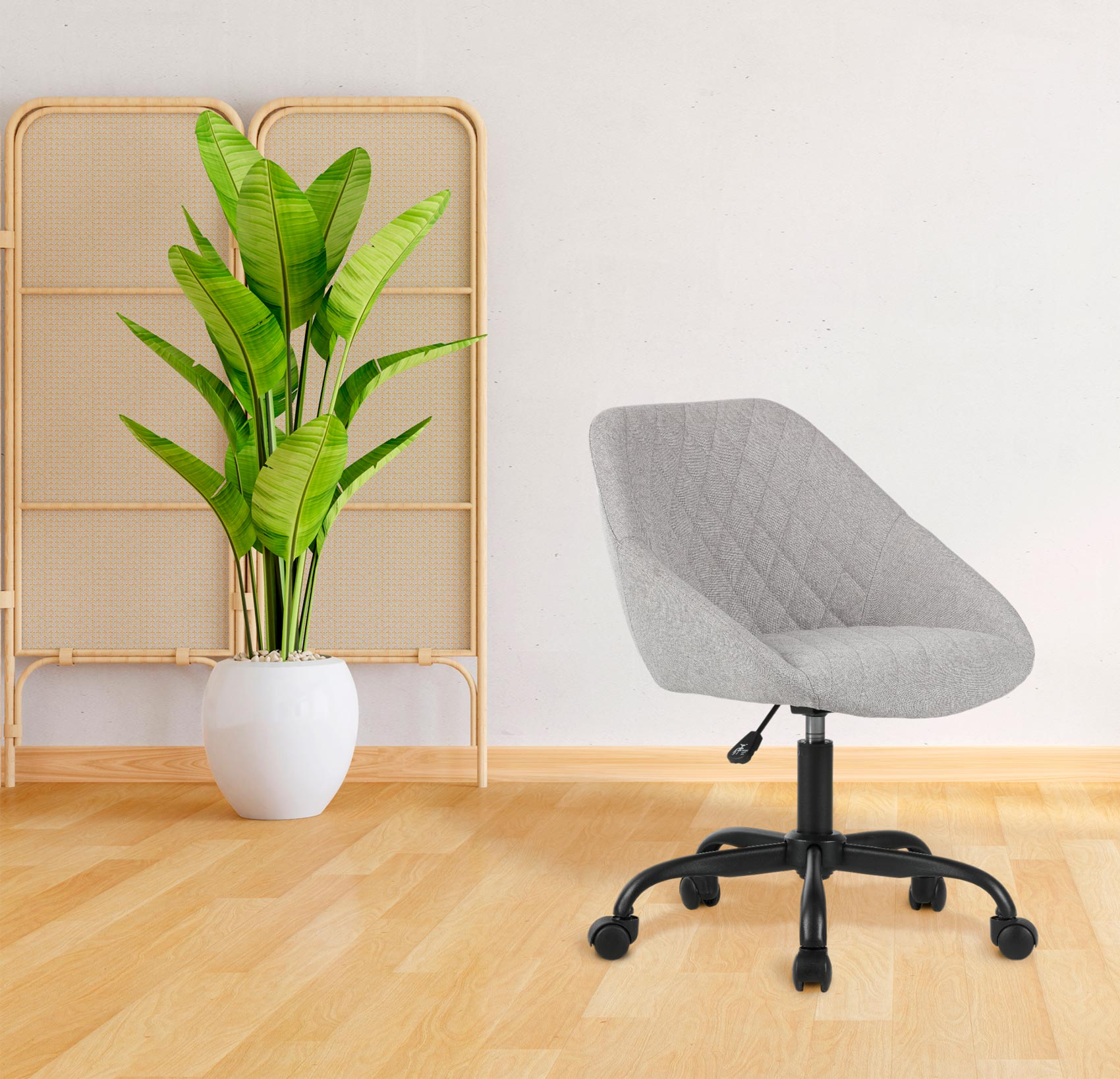 Una silla de oficina gris con ruedas se sienta junto a una planta en maceta y un divisor.