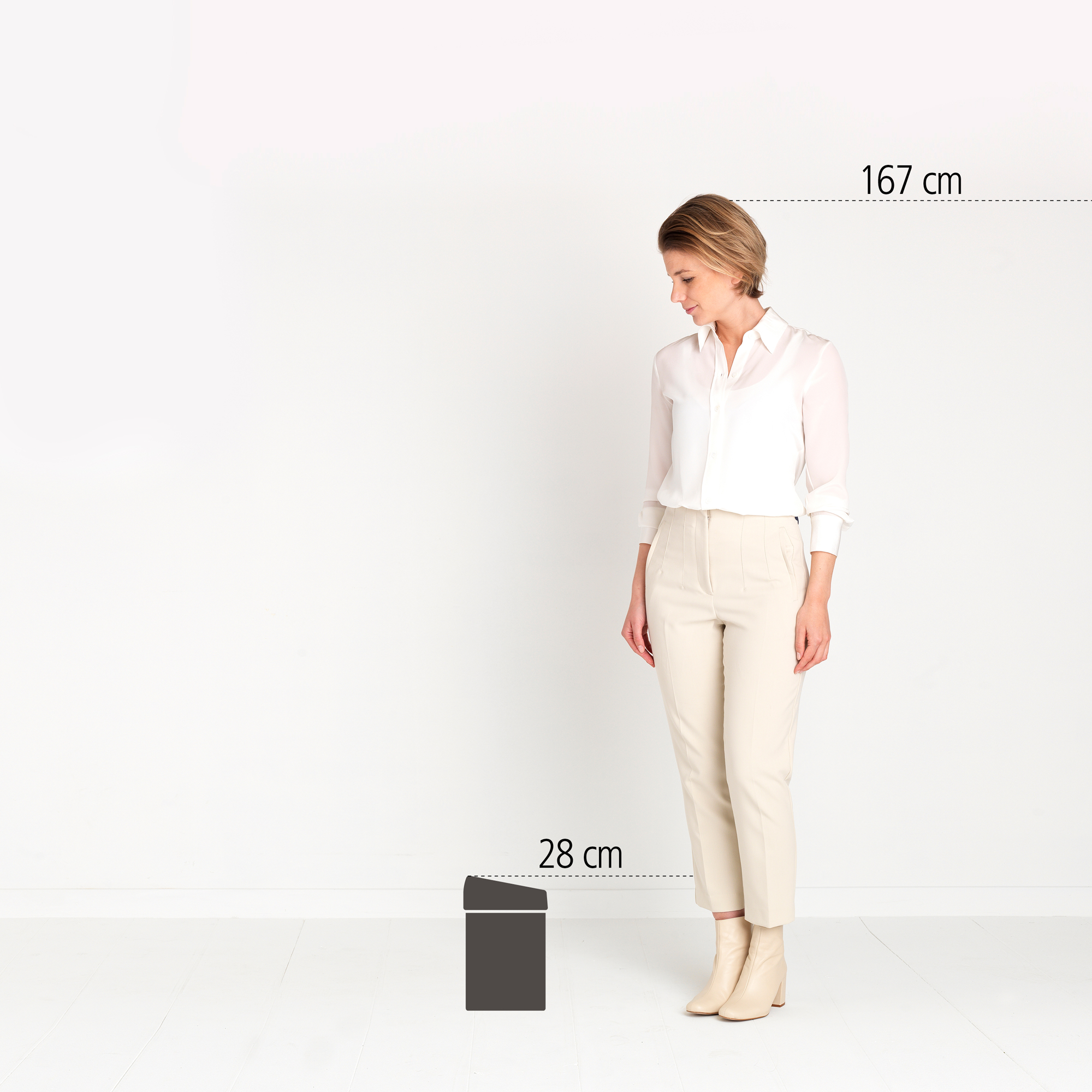 Een vrouw staat naast een donker object van 28 cm hoog.