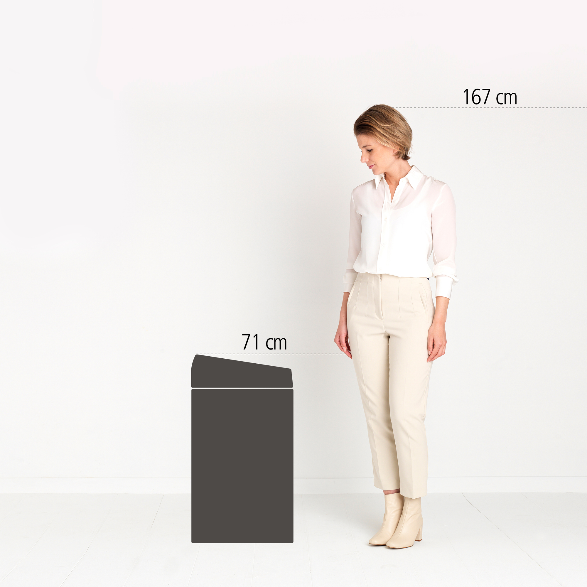Vrouw (167cm) staat naast een donker kastje (71cm).