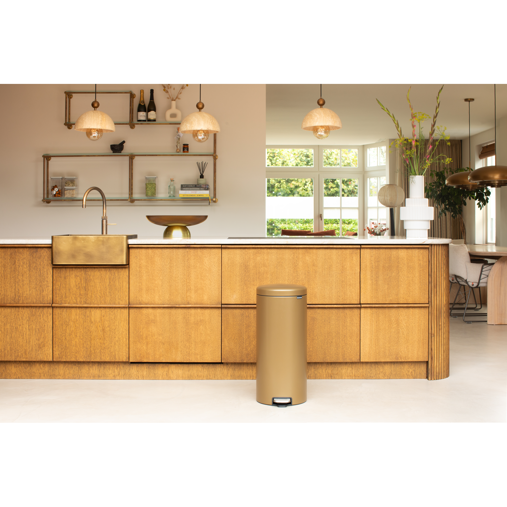 Moderne keuken met gouden prullenbak voor houten kasten en marmeren aanrechtblad.