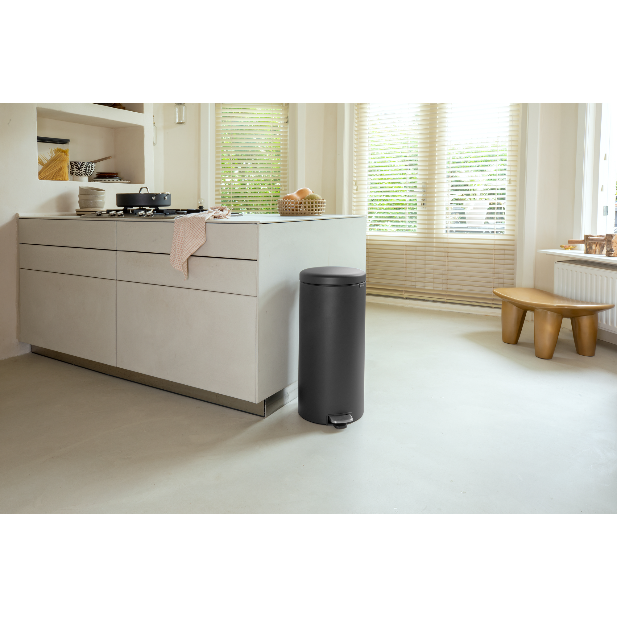 Cocina moderna con cubo de basura oscuro, cocina de gas y ventana.