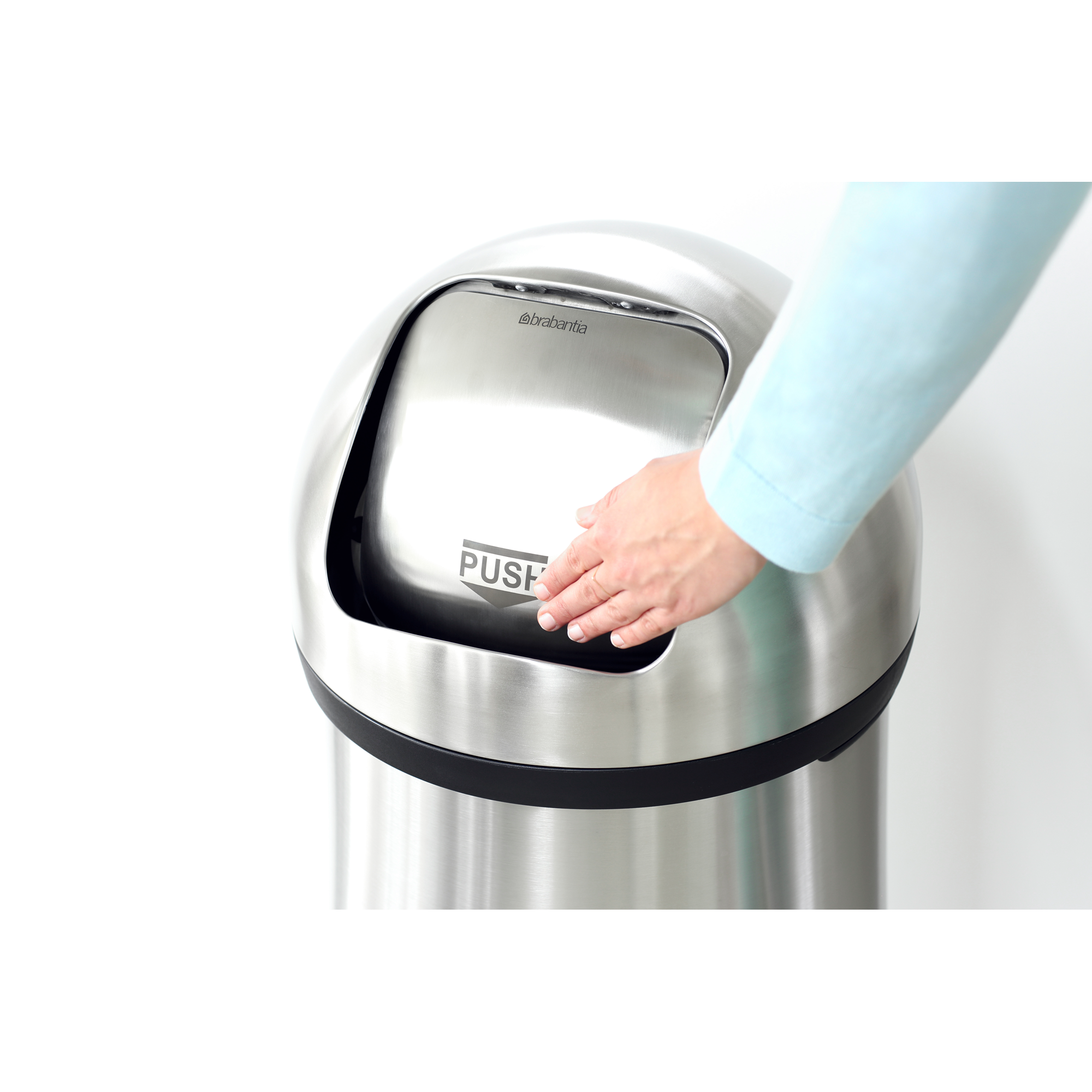 Een hand drukt op de "PUSH"-knop van een zilveren prullenbak.