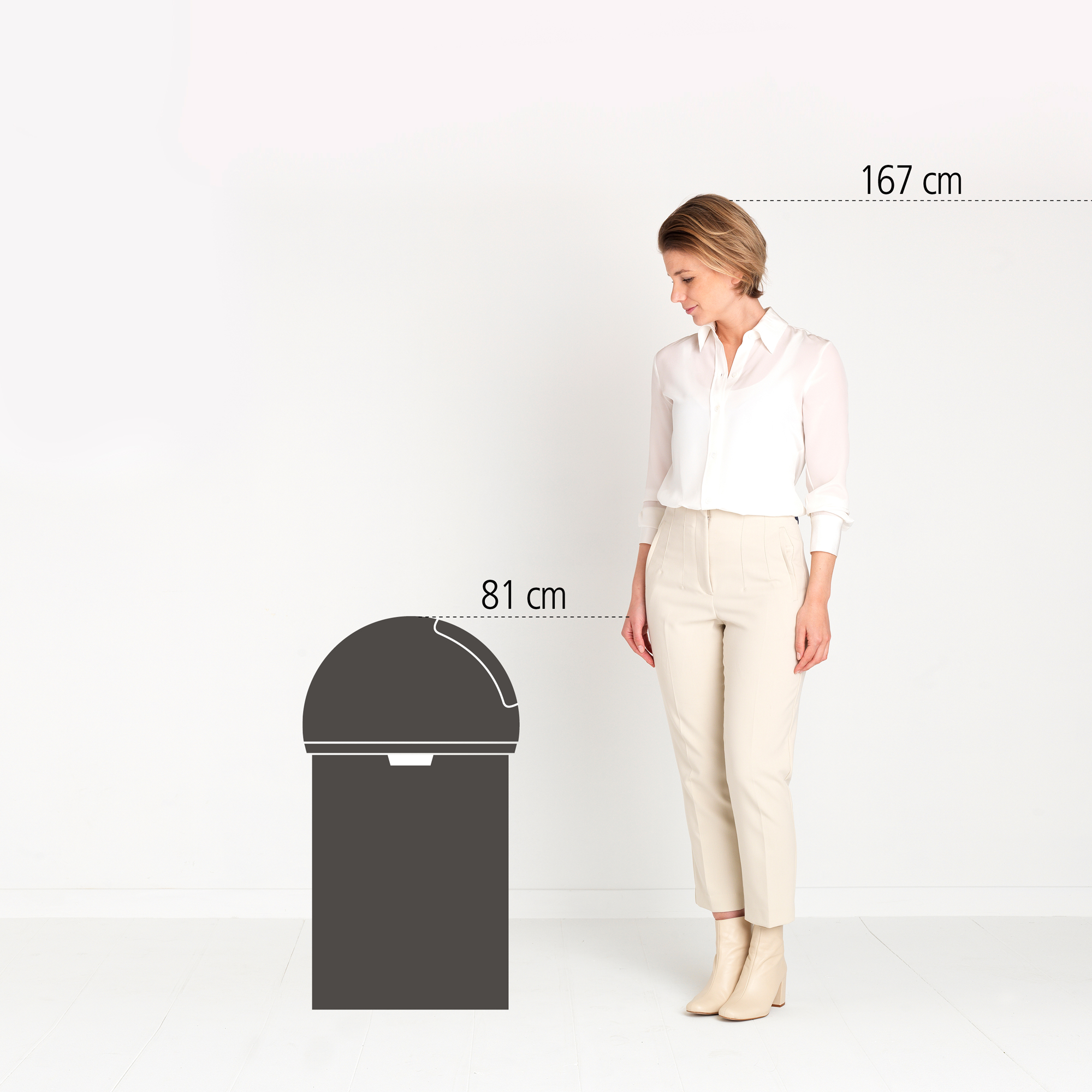 Een vrouw (167 cm) staat naast een prullenbak (81 cm).