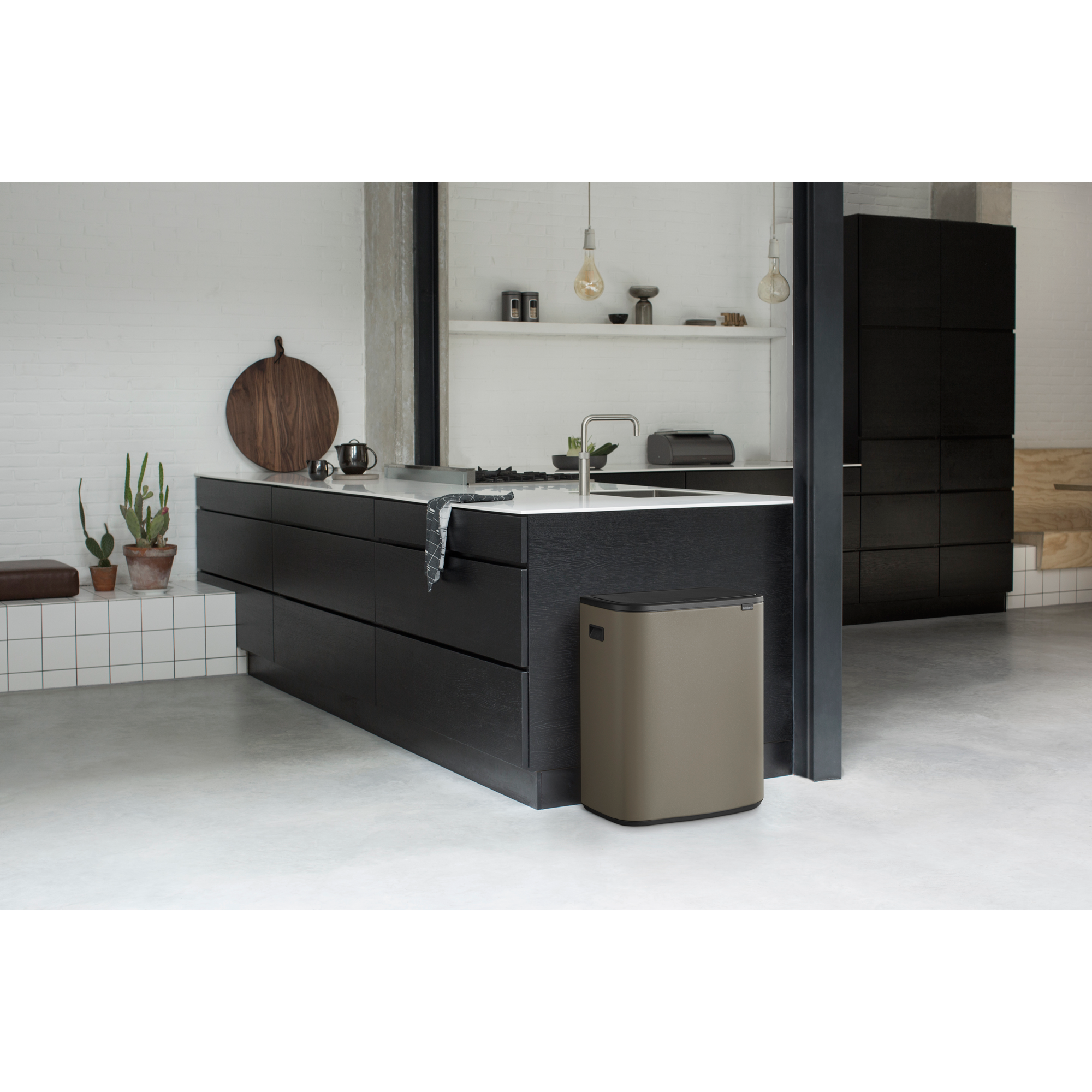 Moderne keuken met donkere kasten, eiland en een prullenbak.