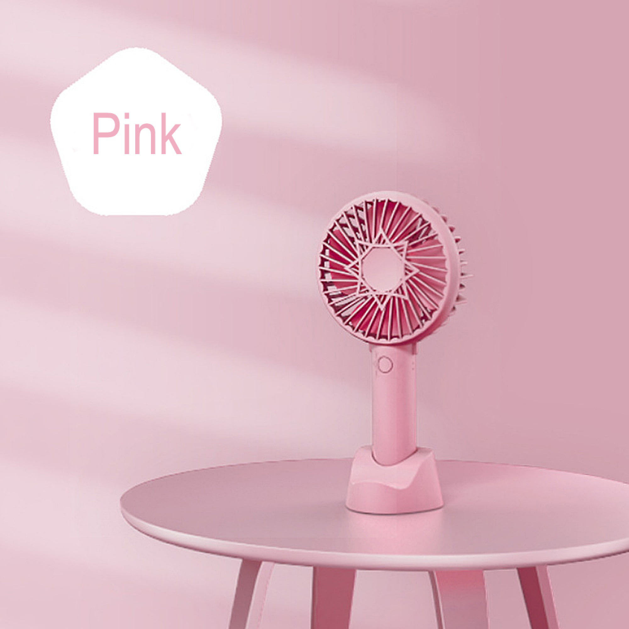 Ein rosa Handventilator steht auf einem runden Tisch. Ein weißes Feld mit der Aufschrift "Pink".