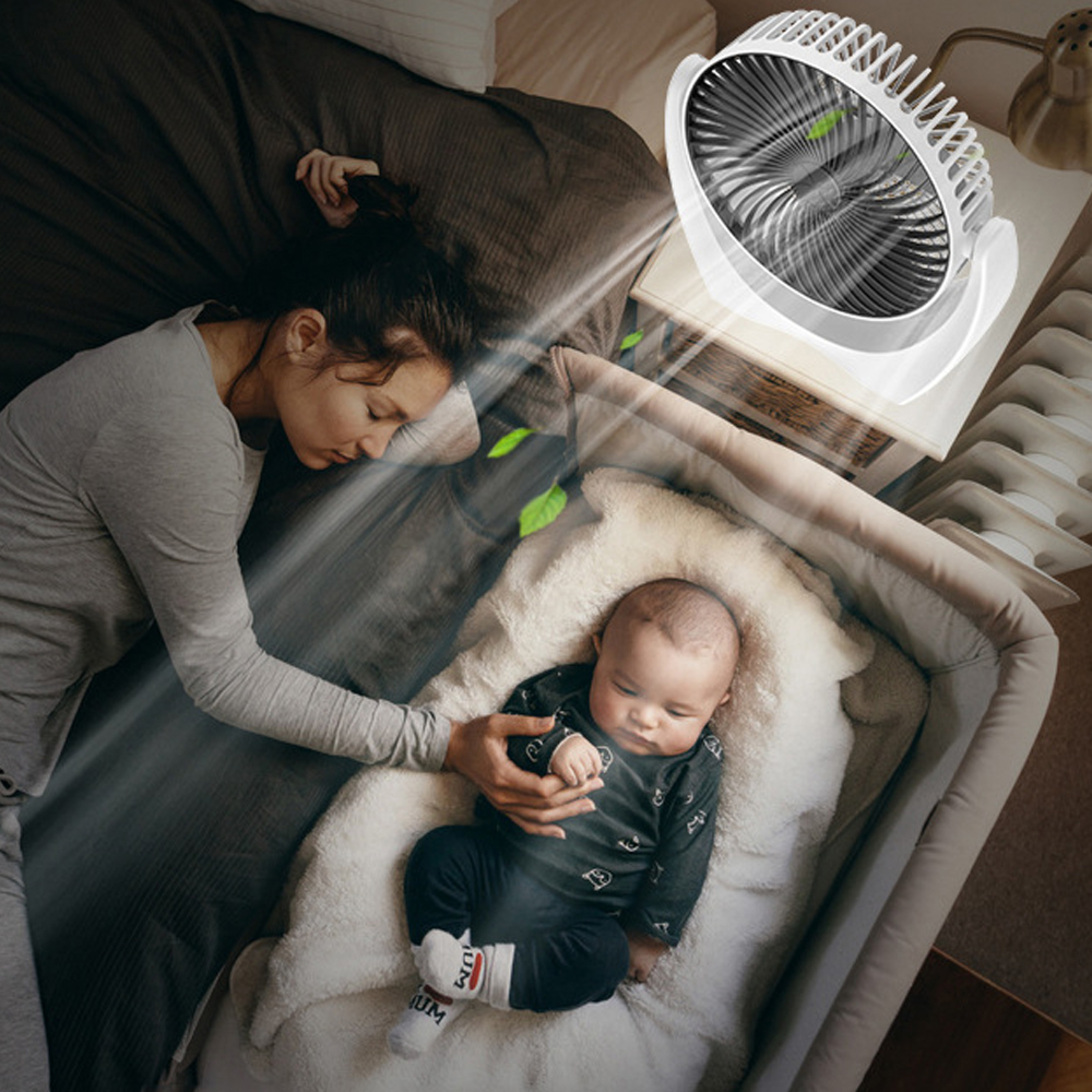 Eine Frau und ein Baby schlafen neben einem Ventilator.