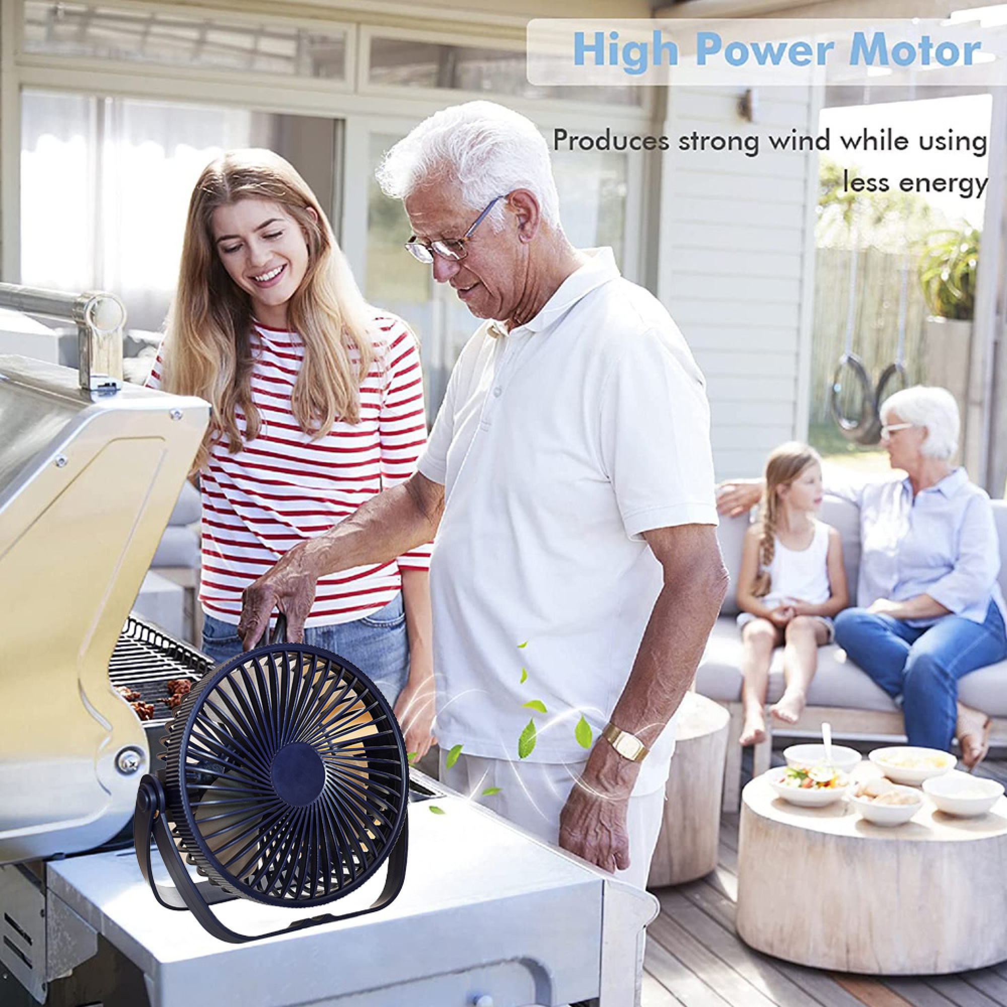 Ein Mann und eine Frau stehen neben einem Grill, ein Ventilator steht auf dem Tisch.