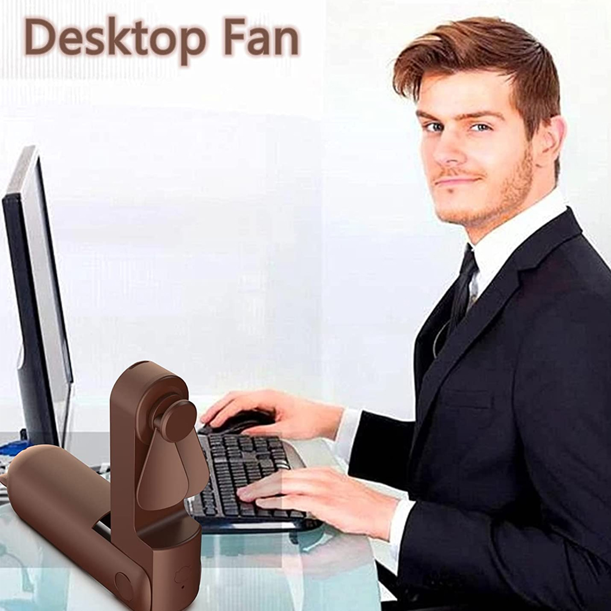 Mann im Anzug tippt auf Tastatur neben einem kleinen Ventilator.