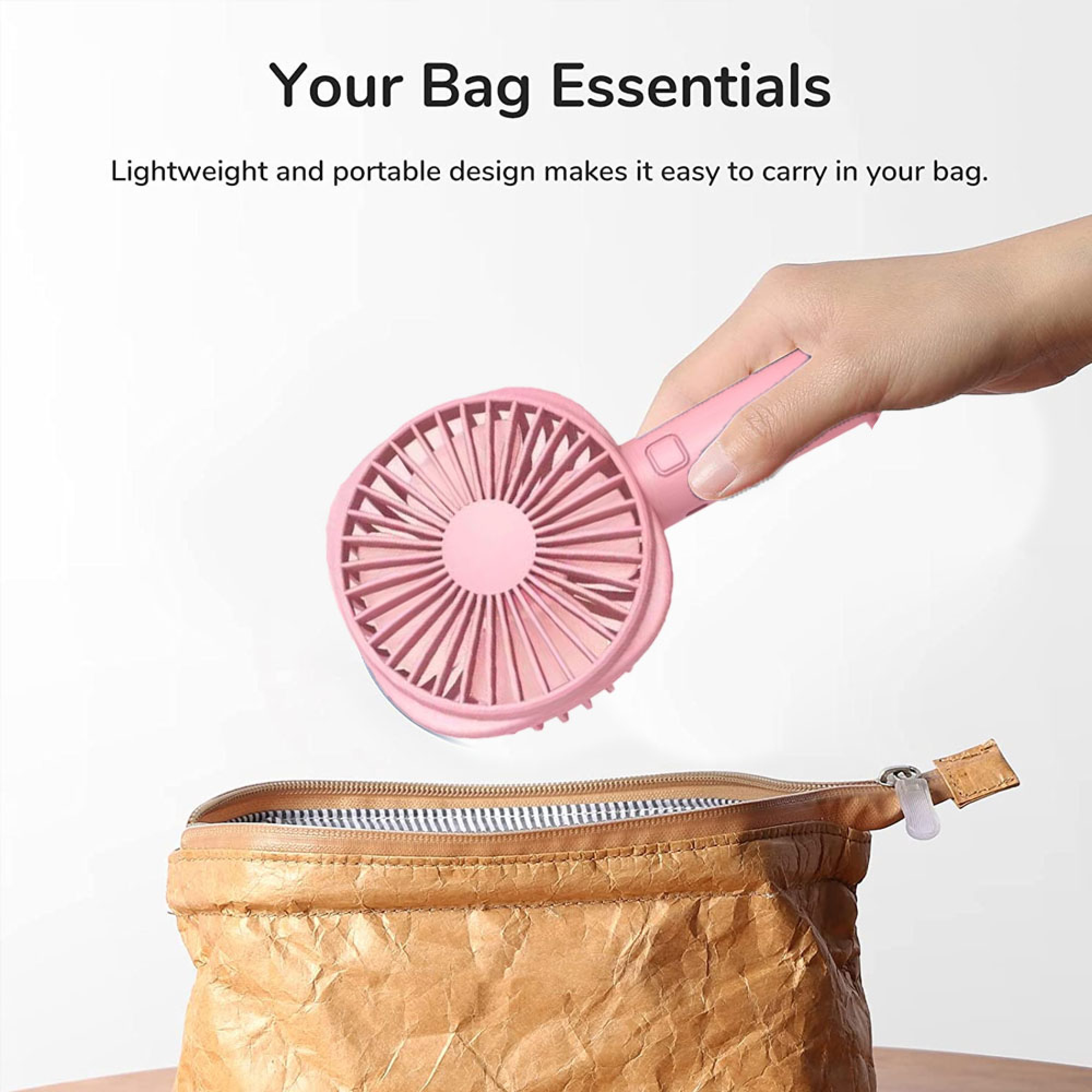 Eine Hand hält einen rosafarbenen Ventilator über eine braune Papiertasche.