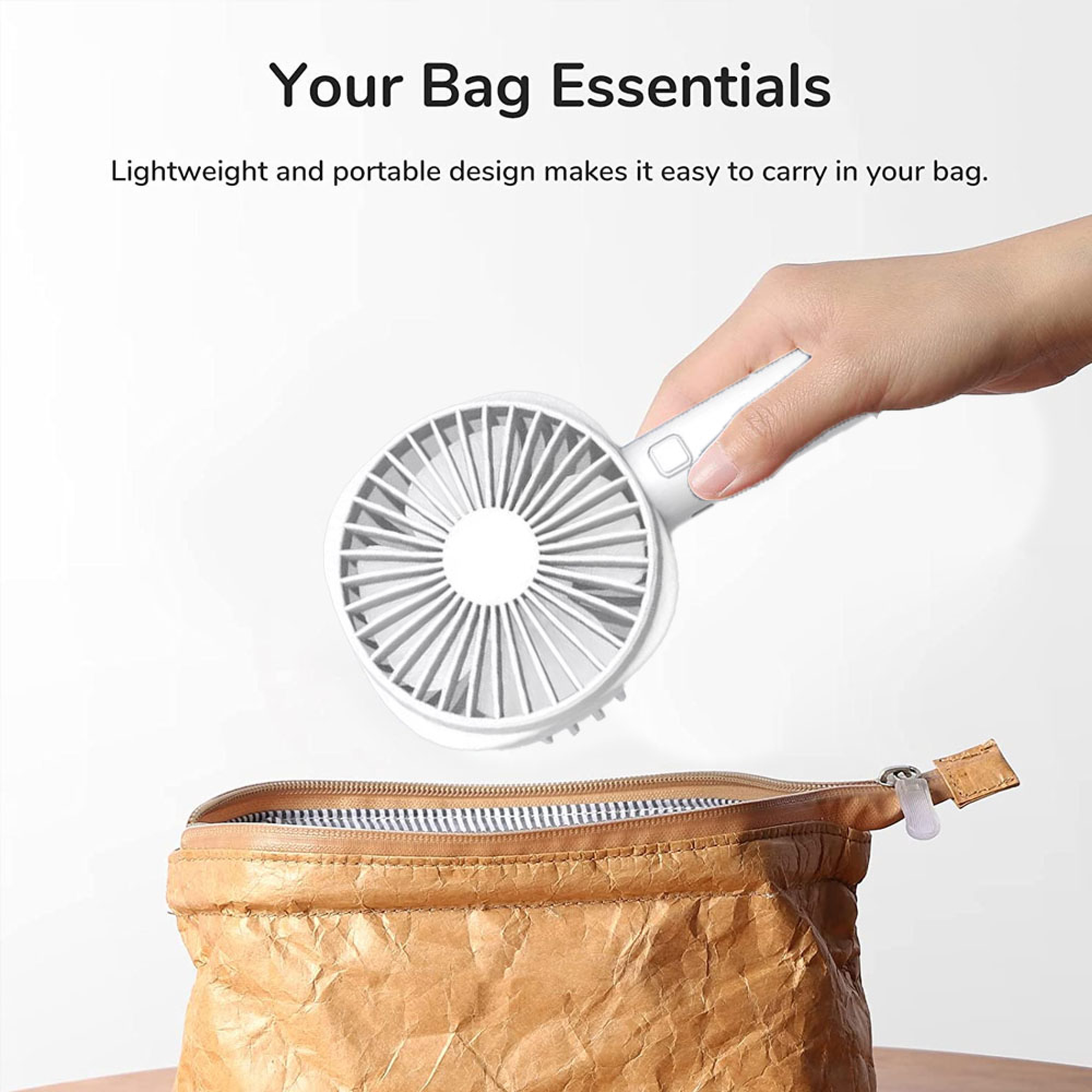 Eine Hand hält einen weißen Mini-Ventilator über einer offenen braunen Tasche.
