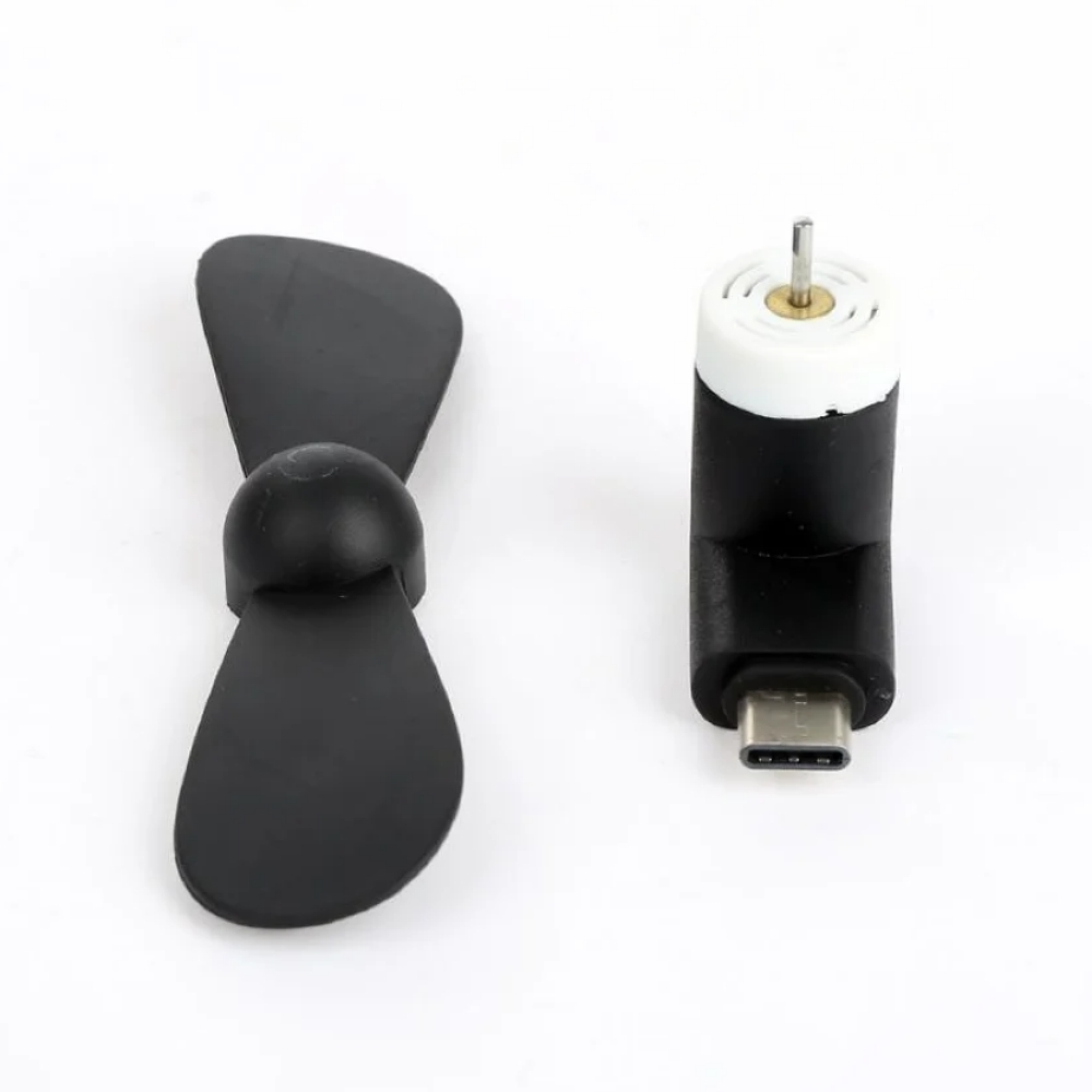 Kleiner schwarzer Propeller neben einem schwarzen USB-C-Motor mit weißem Oberteil.