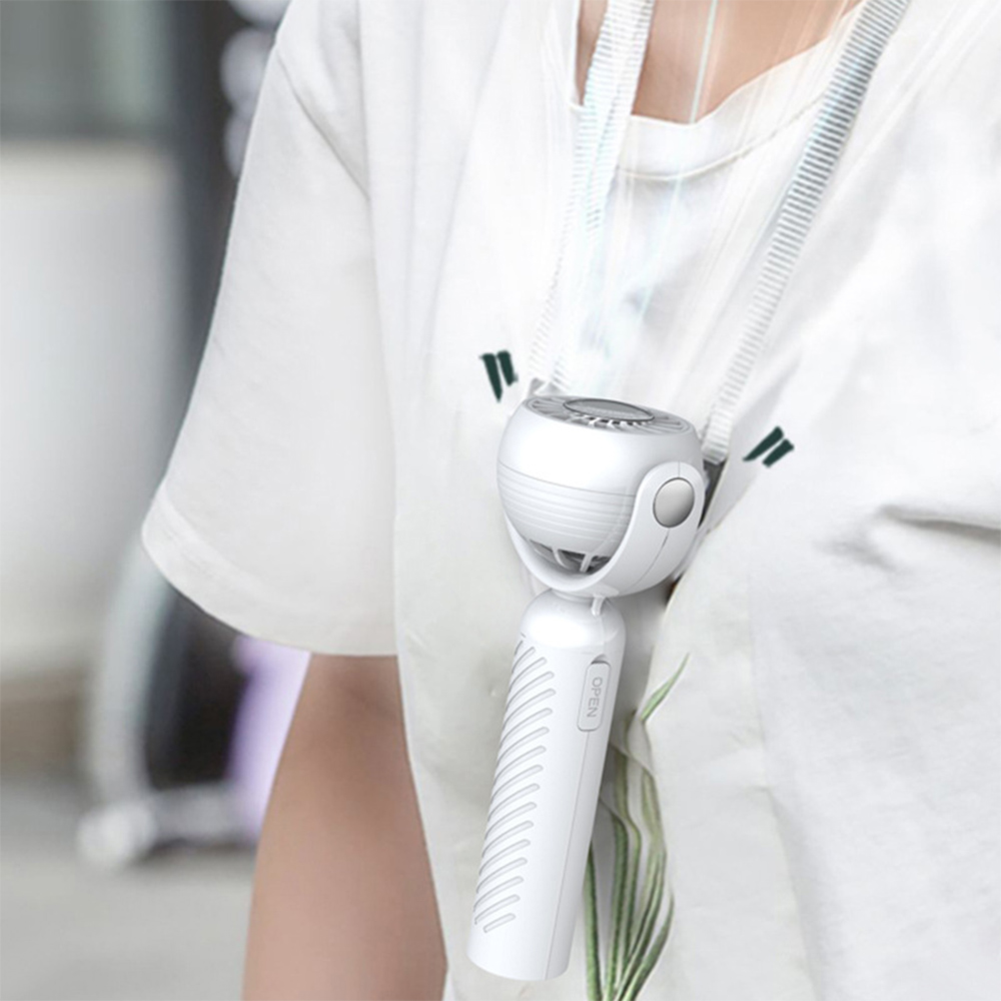 Ein weißer tragbarer Ventilator hängt an einer Lanyards um den Hals einer Person.