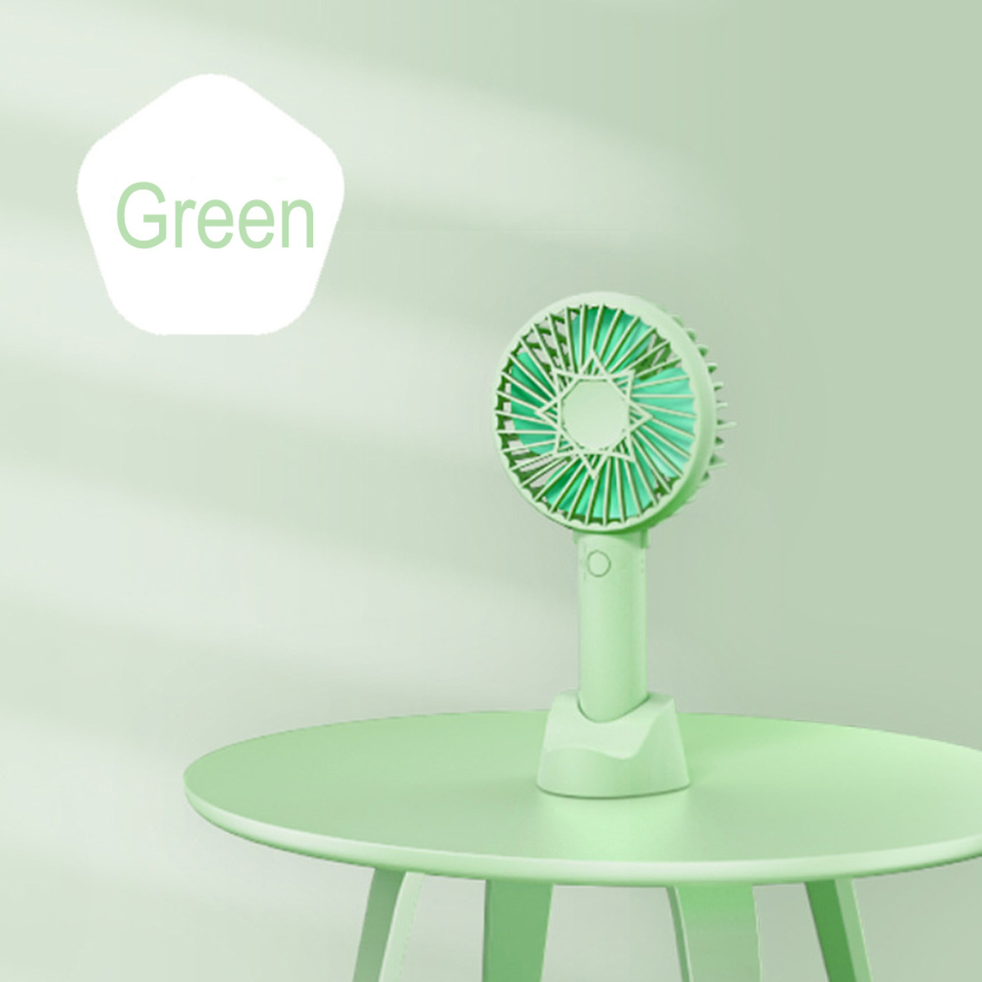 Ein grüner Handventilator steht auf einem hellgrünen Tisch.