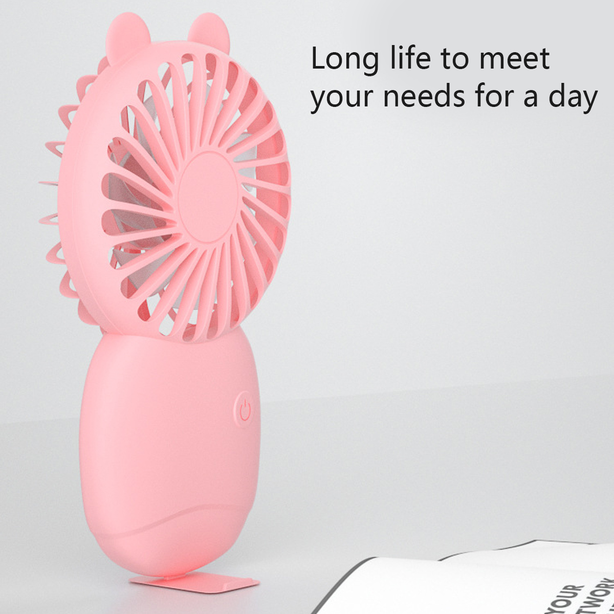 Ein rosafarbener Mini-Ventilator mit Ohren steht auf einem Ständer.