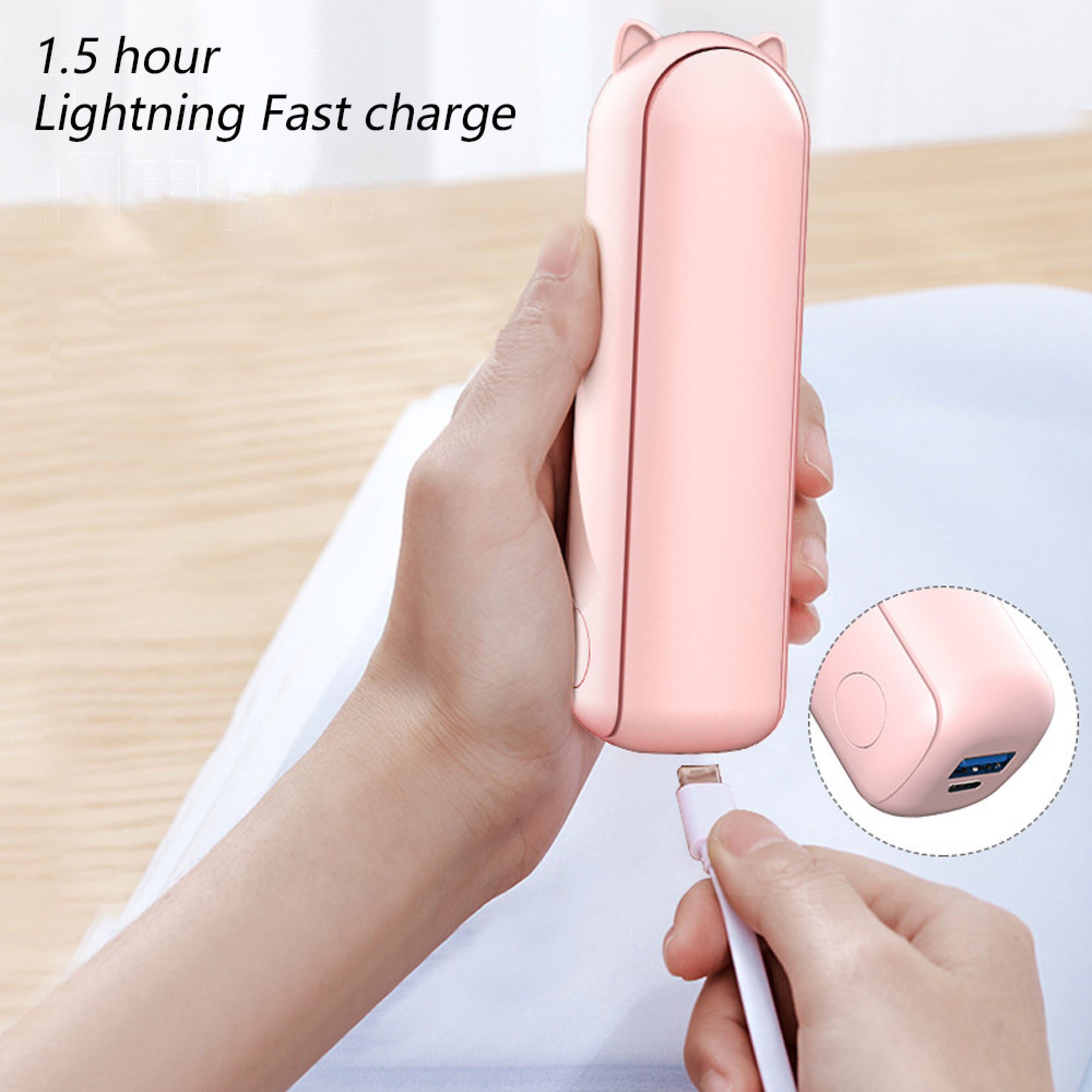 Eine Hand steckt ein USB-C-Kabel in ein rosafarbenes Ladegerät mit Katzenohren.