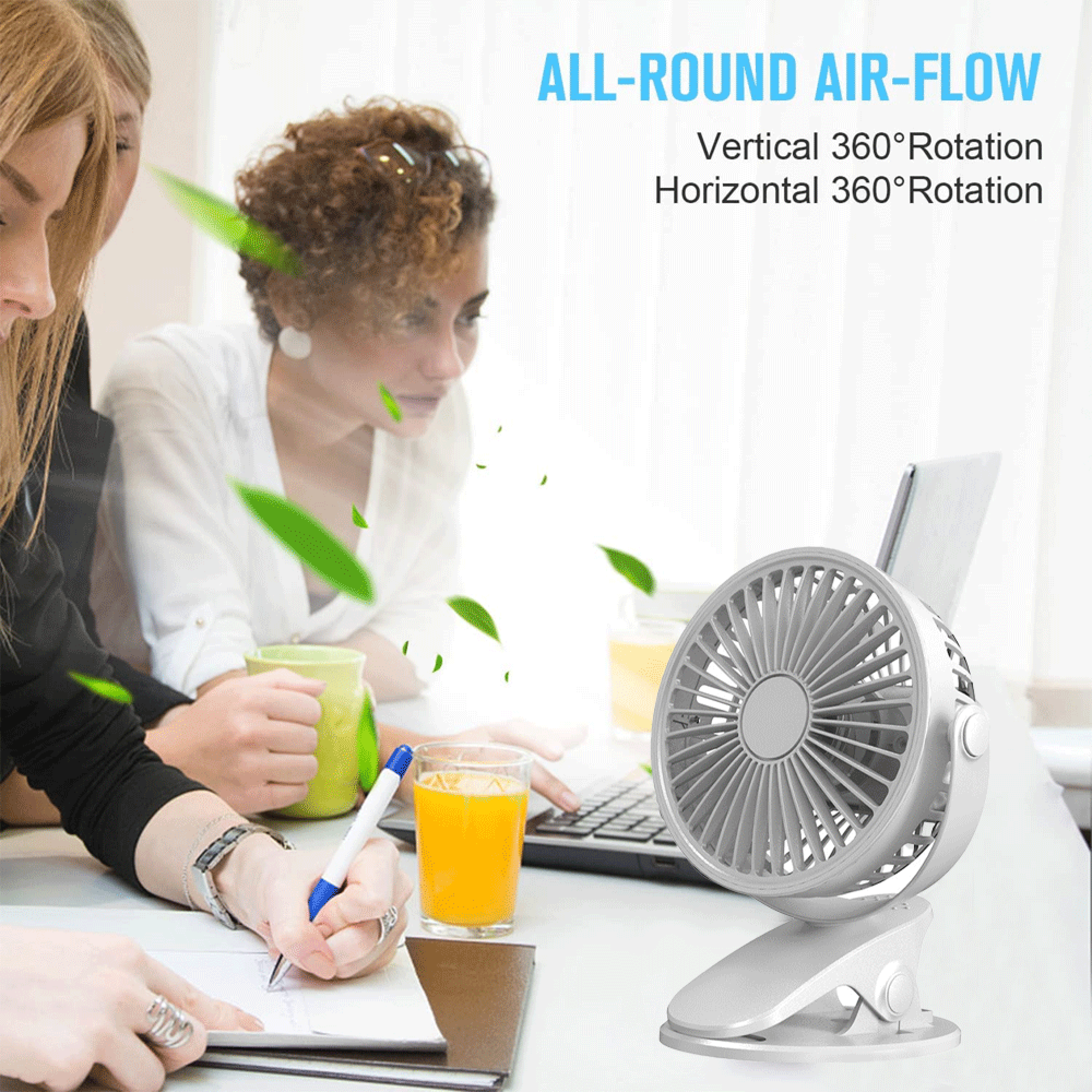 Ein kleiner weißer Ventilator auf einem Clip steht neben einem Laptop und Getränken.