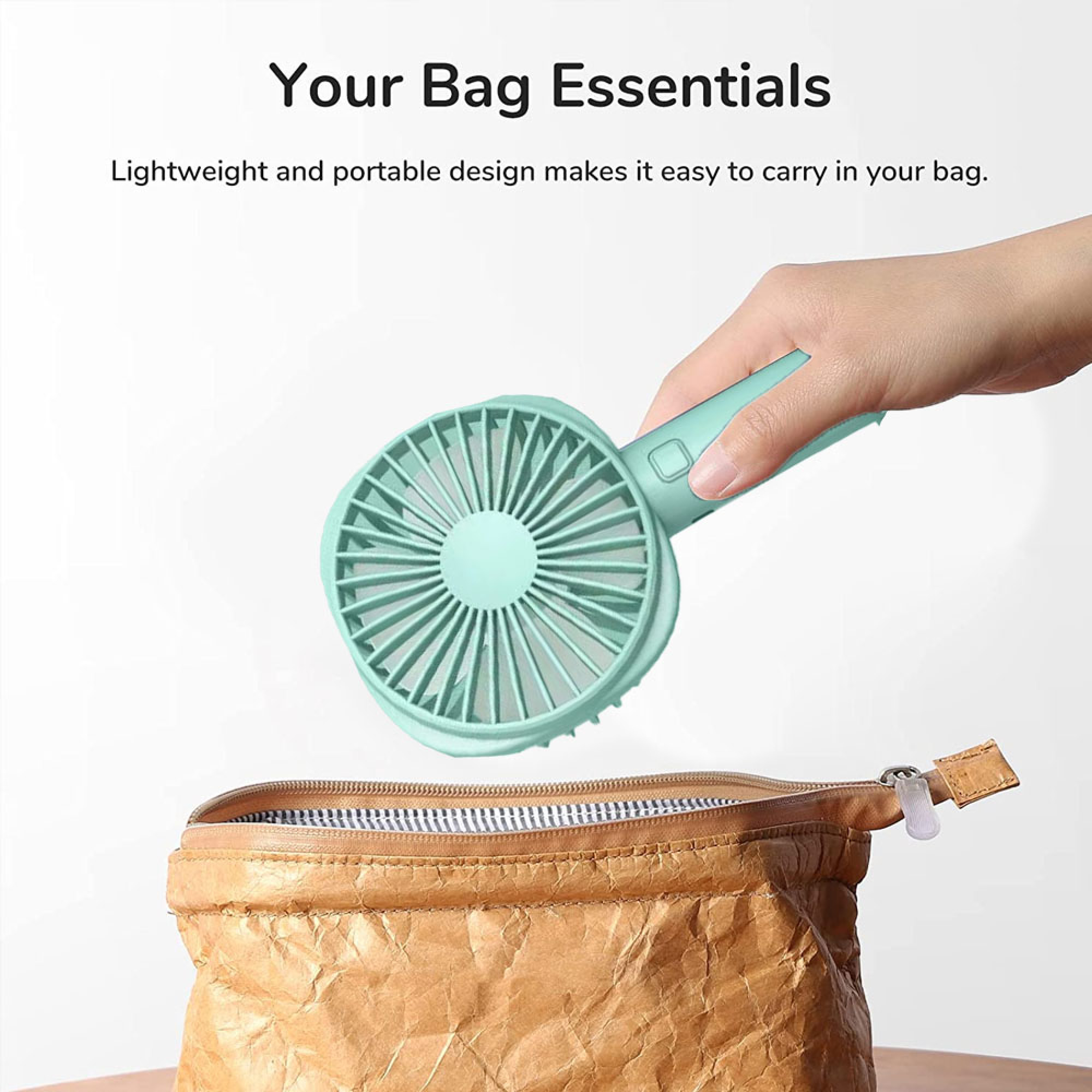 Eine Hand hält einen mintgrünen Ventilator über eine offene braune Papiertasche.