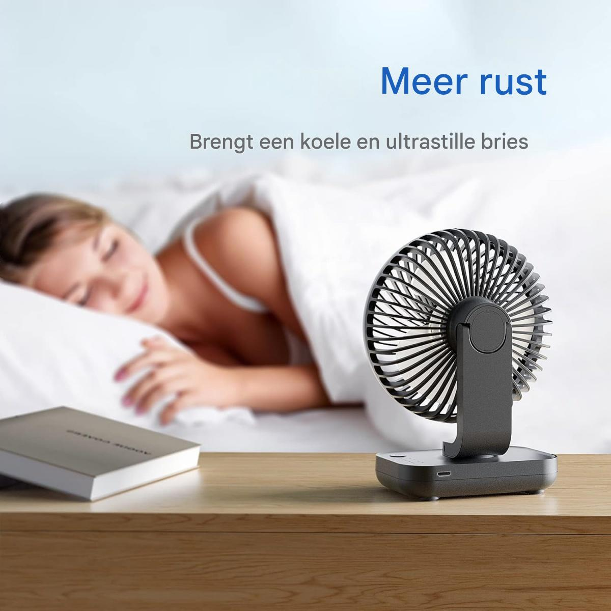 Ein kleiner schwarzer Ventilator steht auf einem Nachttisch neben einem schlafenden Mädchen.