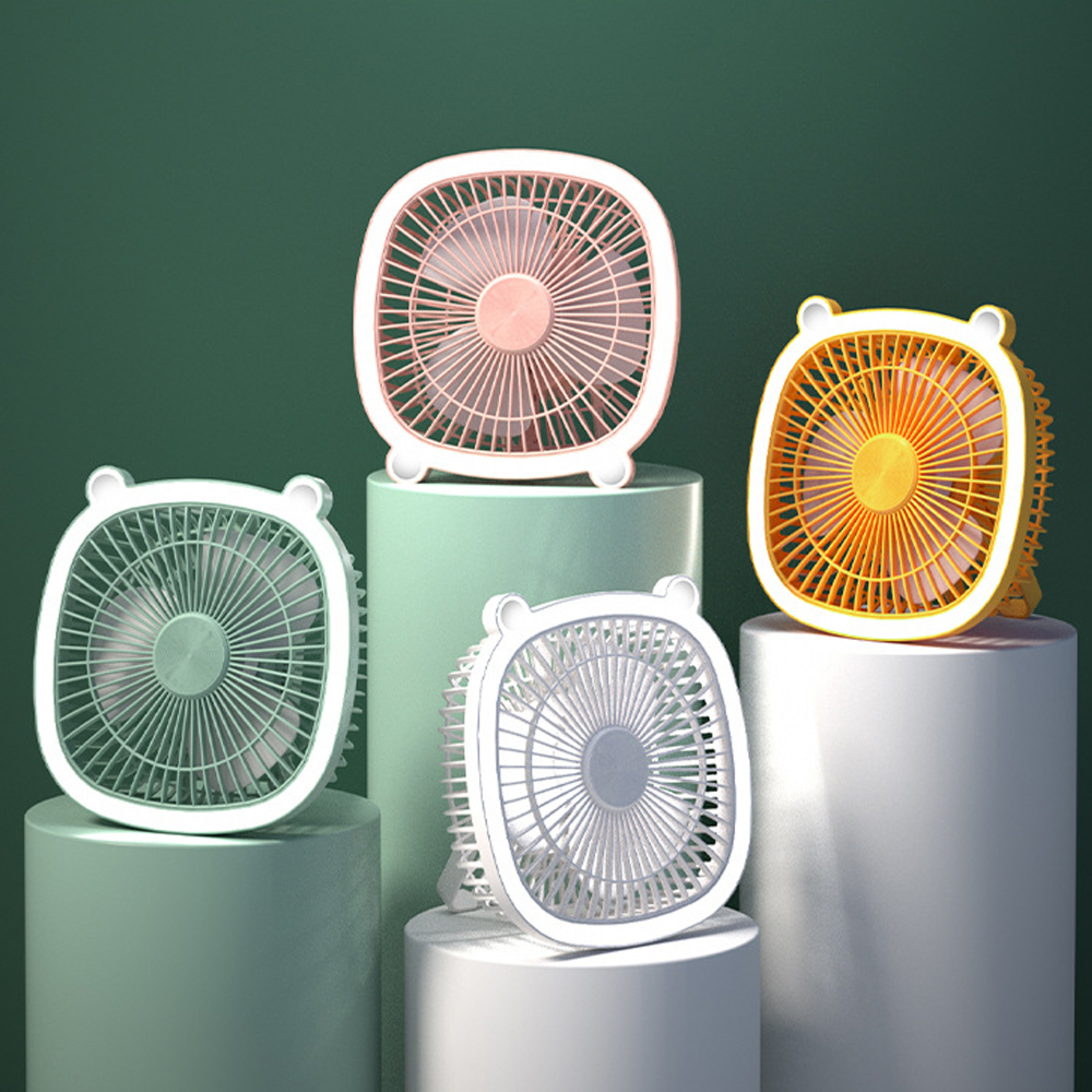 Vier kleine Ventilatoren in Pastellfarben auf Podesten vor einem grünen Hintergrund.