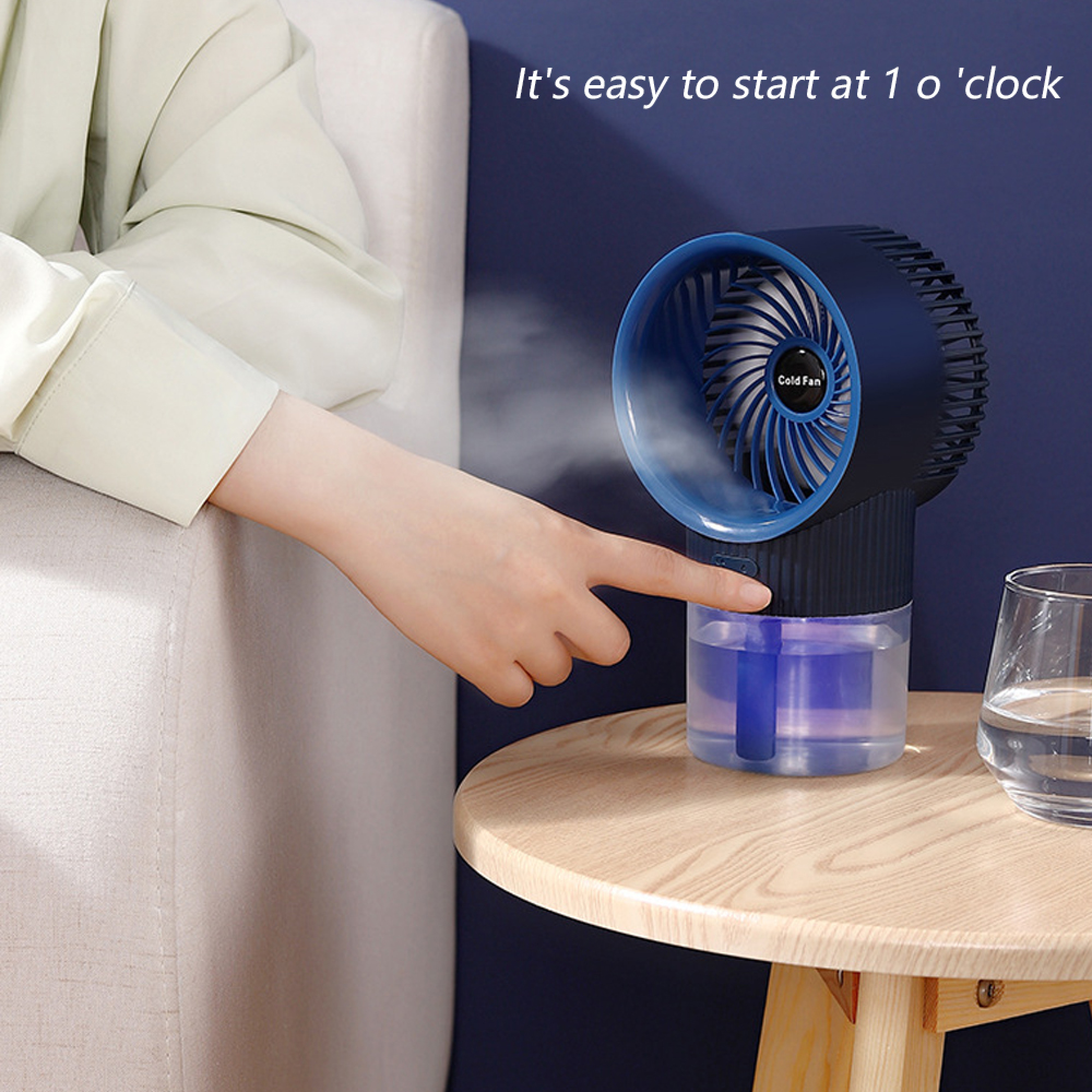 Eine Hand drückt einen blauen Mini-Kühler mit Wassertank und Nebel aus.