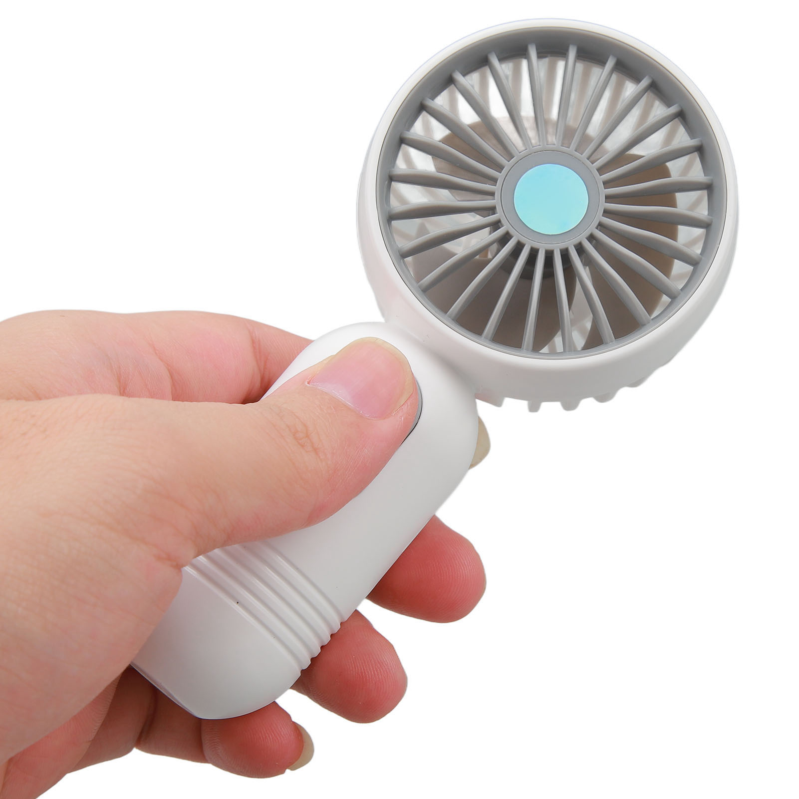 Eine Hand hält einen kleinen weißen Ventilator mit grauen Rotorblättern.