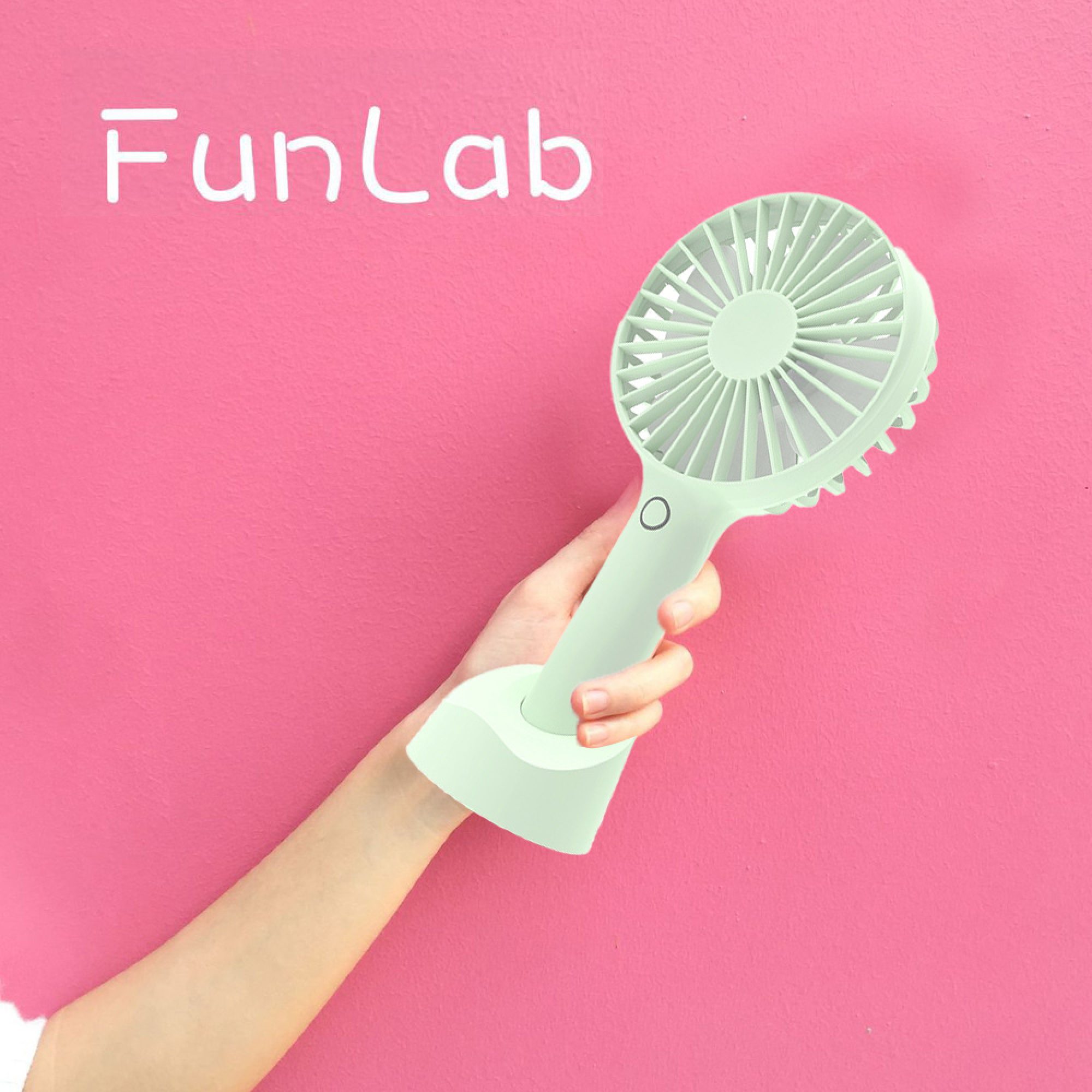 Eine Hand hält einen mintgrünen, tragbaren Ventilator vor einem rosa Hintergrund mit "FunLab"-Schriftzug.