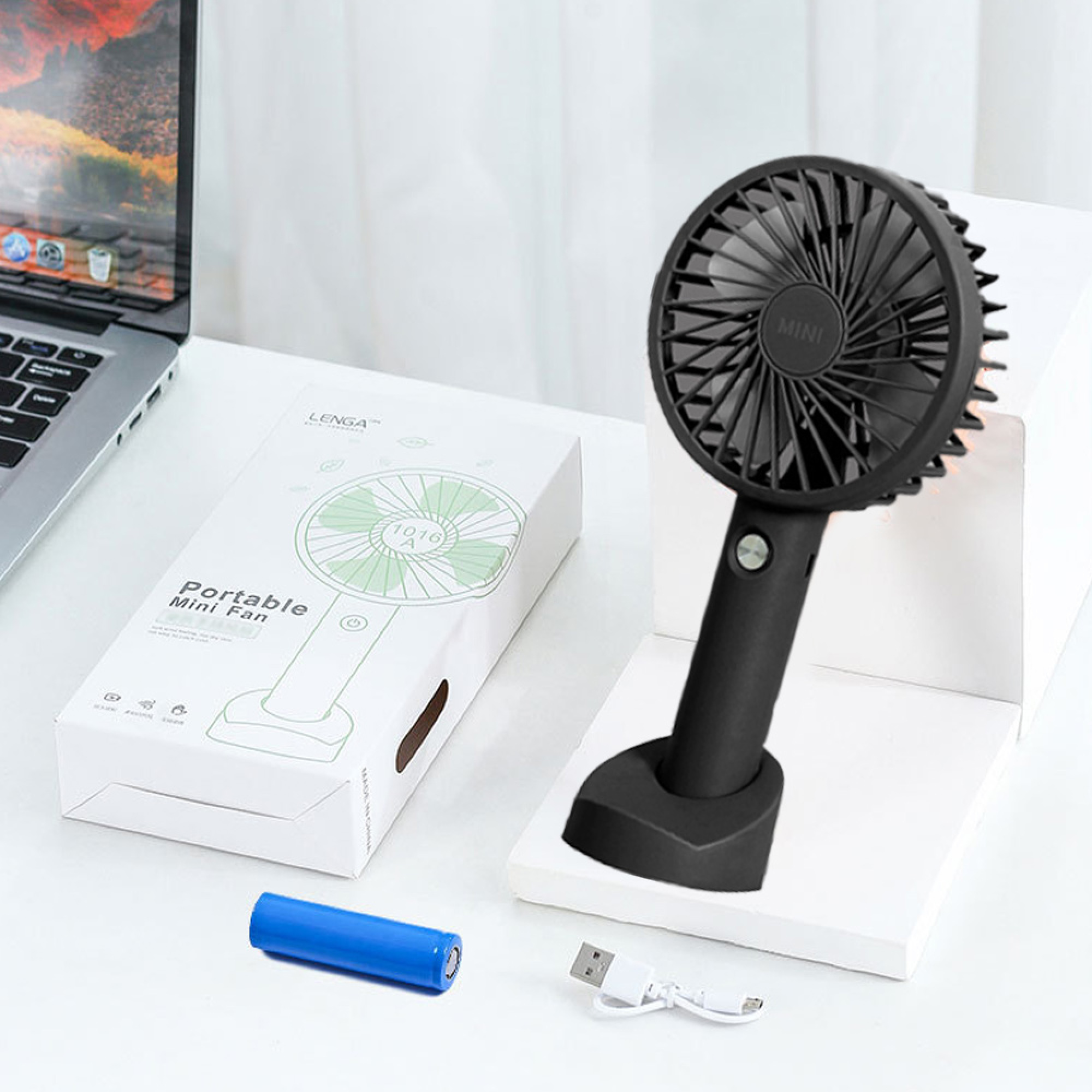 Ein schwarzer tragbarer Mini-Ventilator mit Box, blauer Batterie und USB-Kabel.
