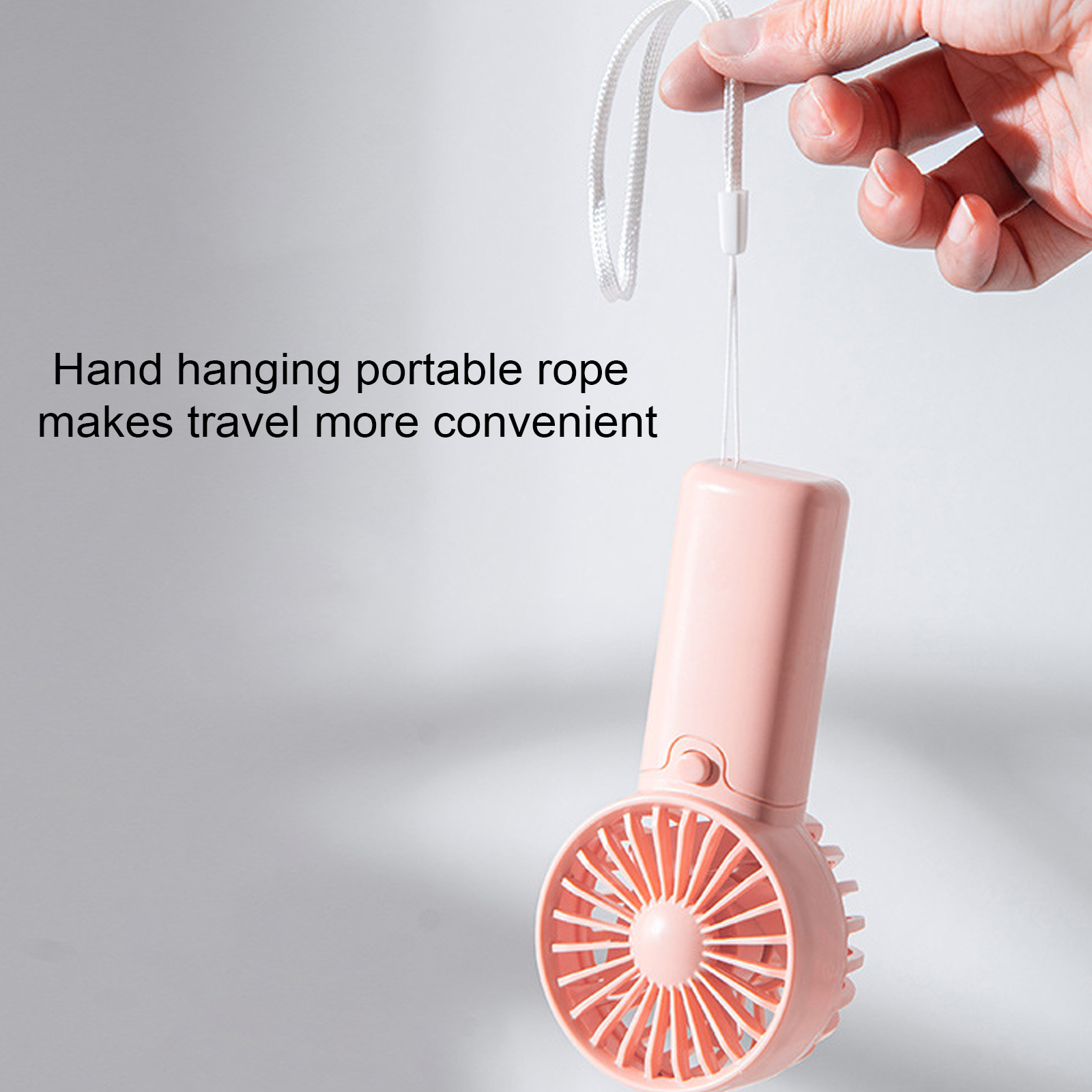 Eine Hand hält einen rosa Ventilator mit Lanyard an einem grauen Hintergrund.