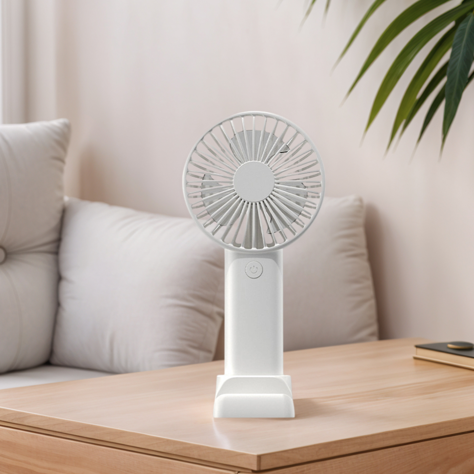 Ein weißer Handventilator steht auf einem Holztisch vor einem Sofa mit Kissen.
