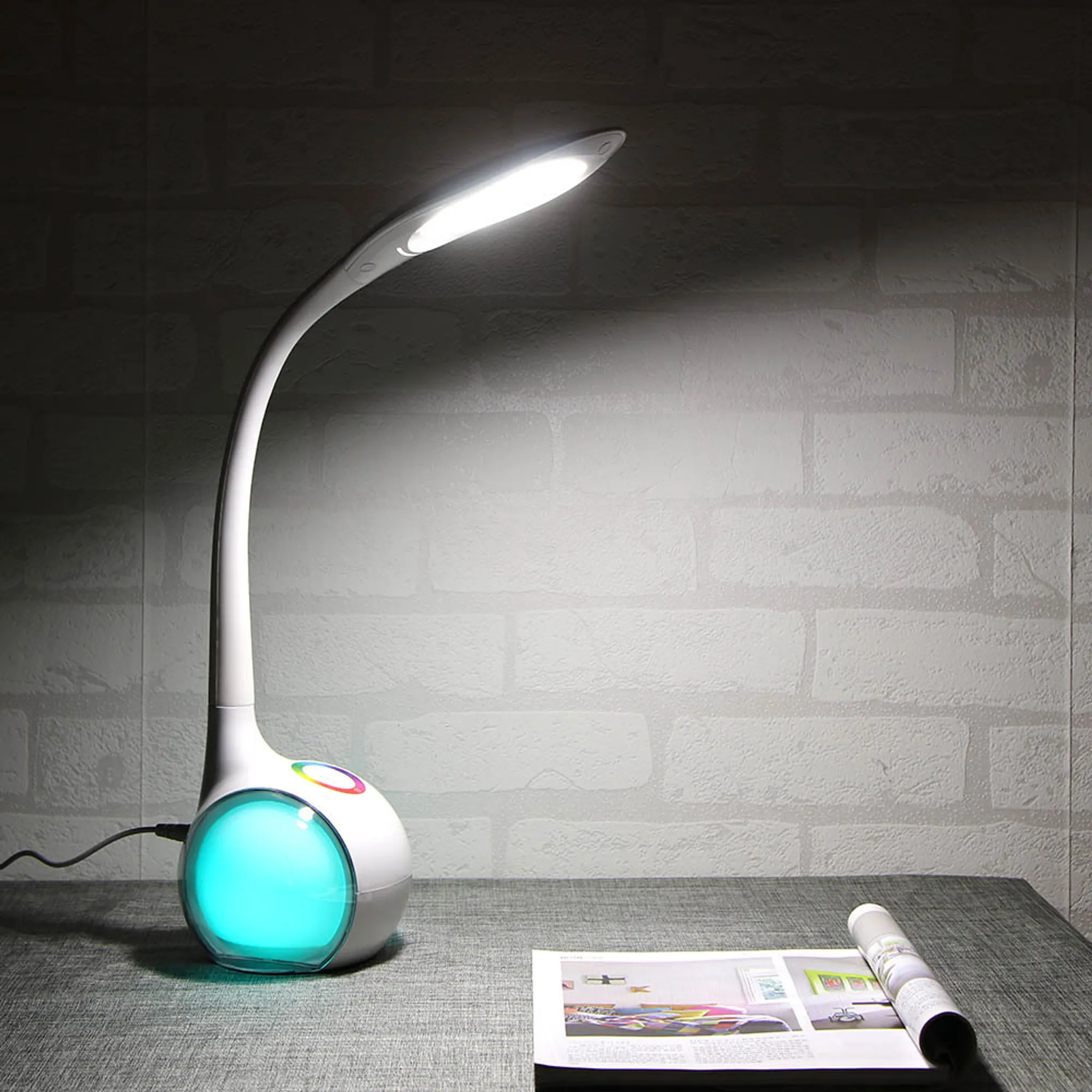 Moderne Schreibtischlampe mit blauem Lichtsockel und schwenkbarem Arm.