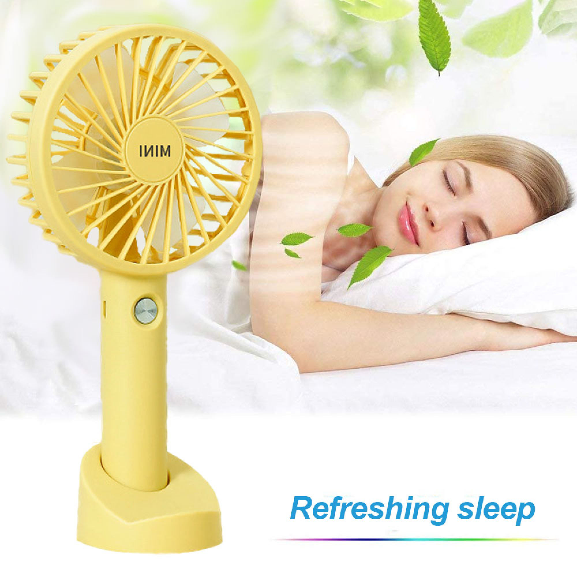 Ein gelber Mini-Ventilator steht neben einer schlafenden Frau auf einem weißen Bett. Grüne Blätter schweben.