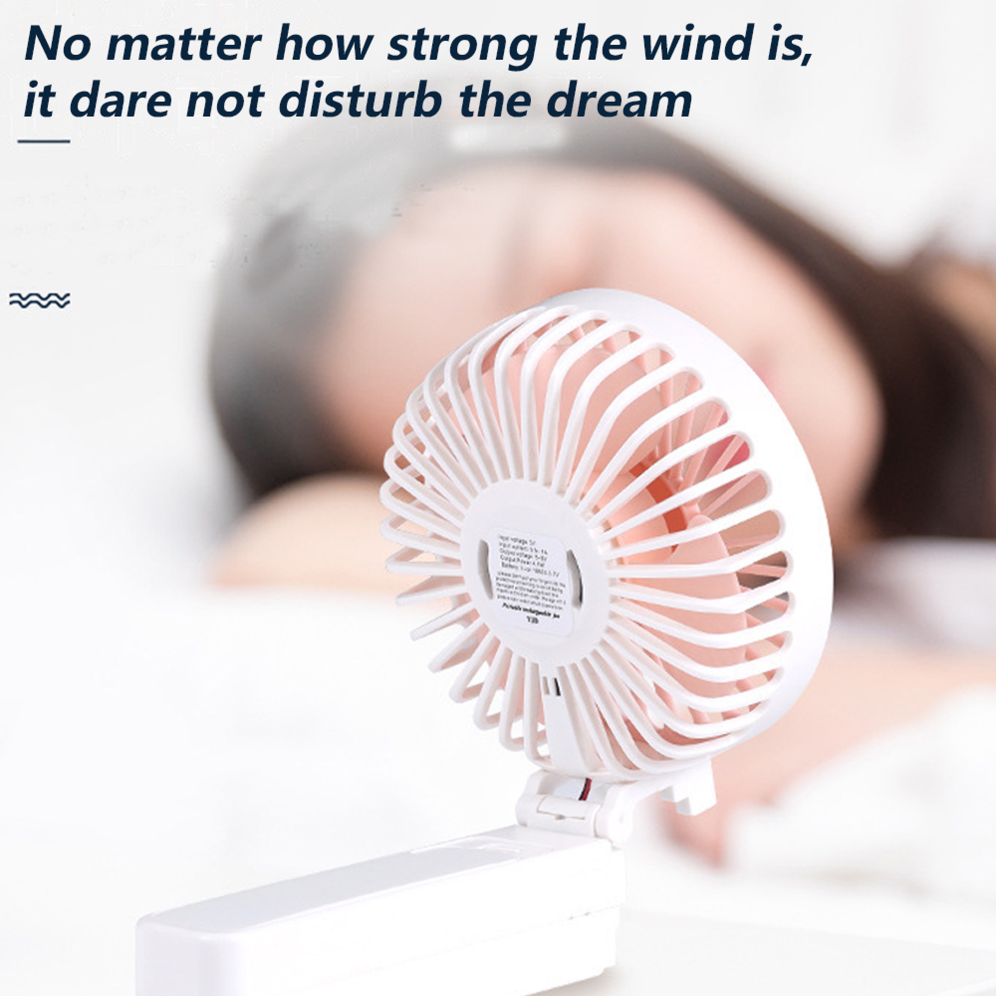 Ein kleiner weißer Ventilator steht auf einer Oberfläche, dahinter eine Person.