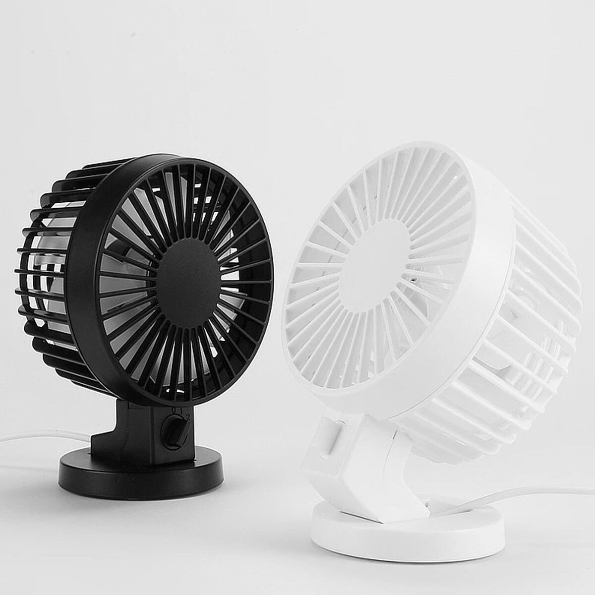 Ein schwarzer und ein weißer Ventilator stehen nebeneinander.