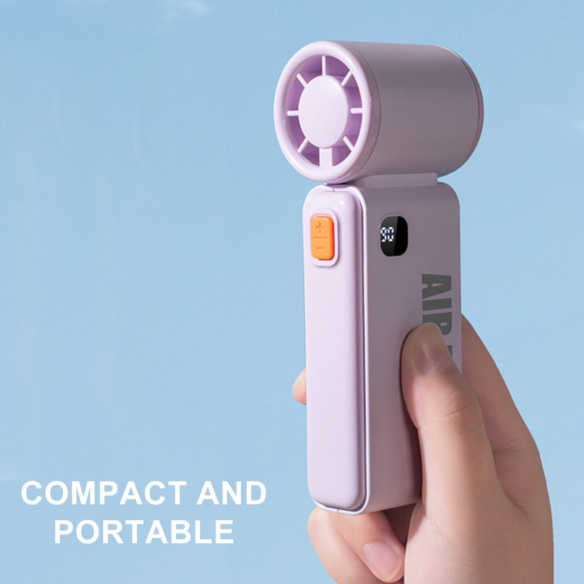 Eine Hand hält einen lila Ventilator mit orangefarbenem Knopf und Digitalanzeige.