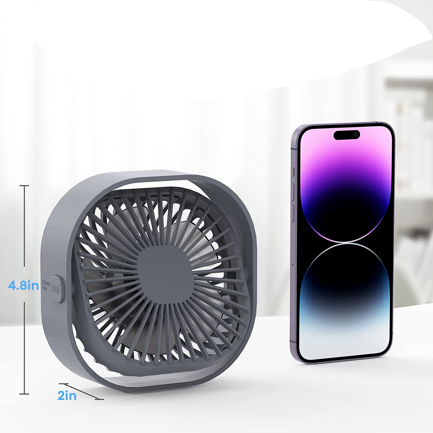 Ein grauer Ventilator und ein Smartphone mit lila Hintergrund stehen nebeneinander.