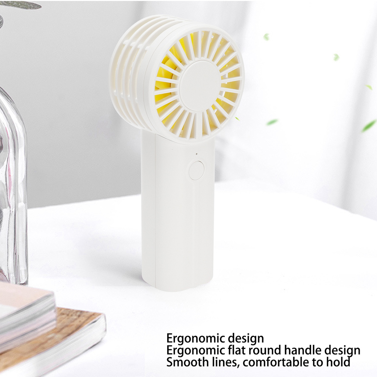 Ein weißer Handventilator mit gelben Rotorblättern steht auf einem Tisch.