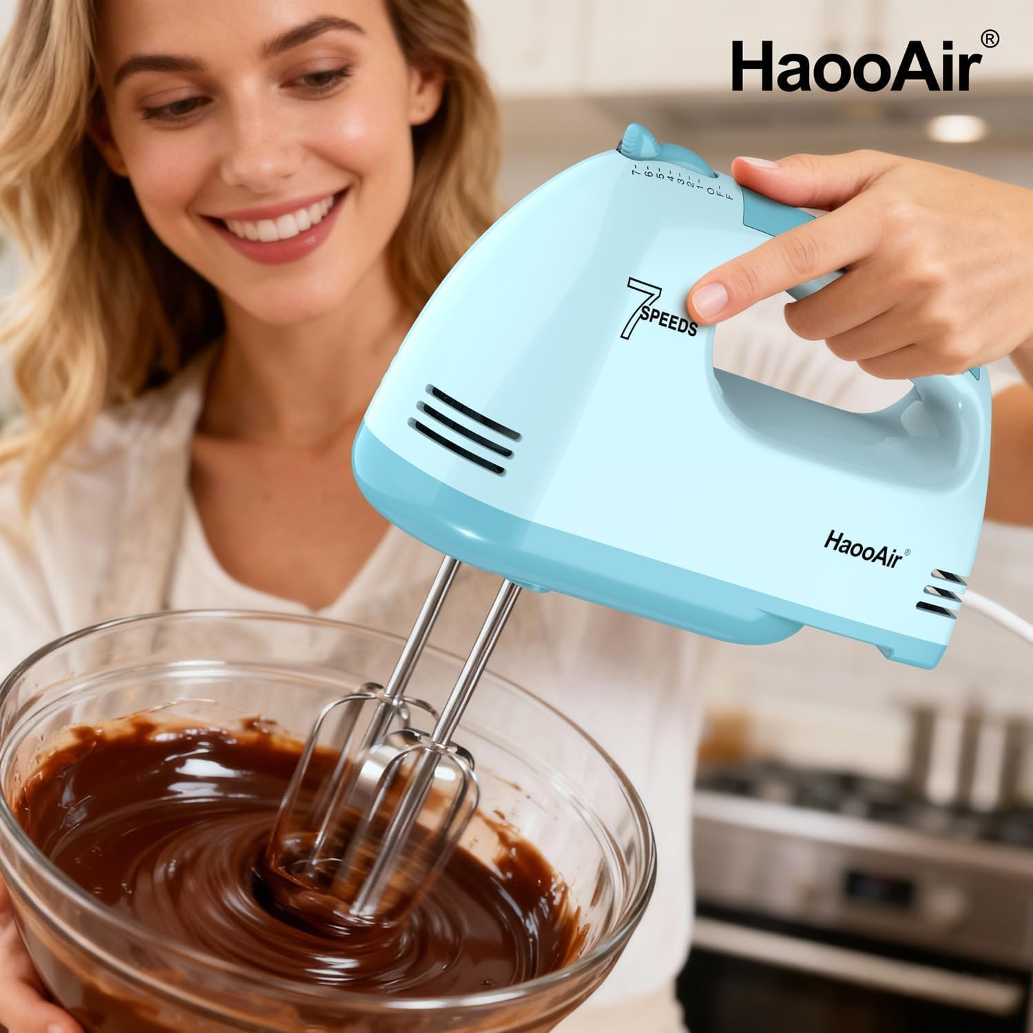 Eine Frau mixt Schokolade mit einem hellblauen Handmixer in einer Glasschüssel.