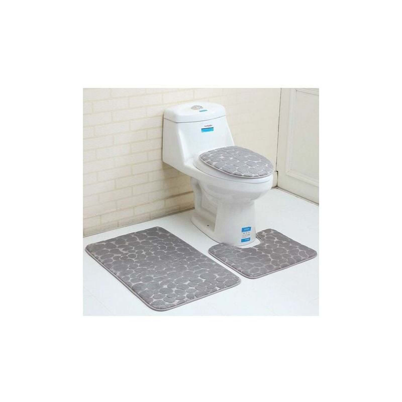 Ein weißes WC mit grauem Muster auf Sitz und Matten vor einer Ziegelwand.