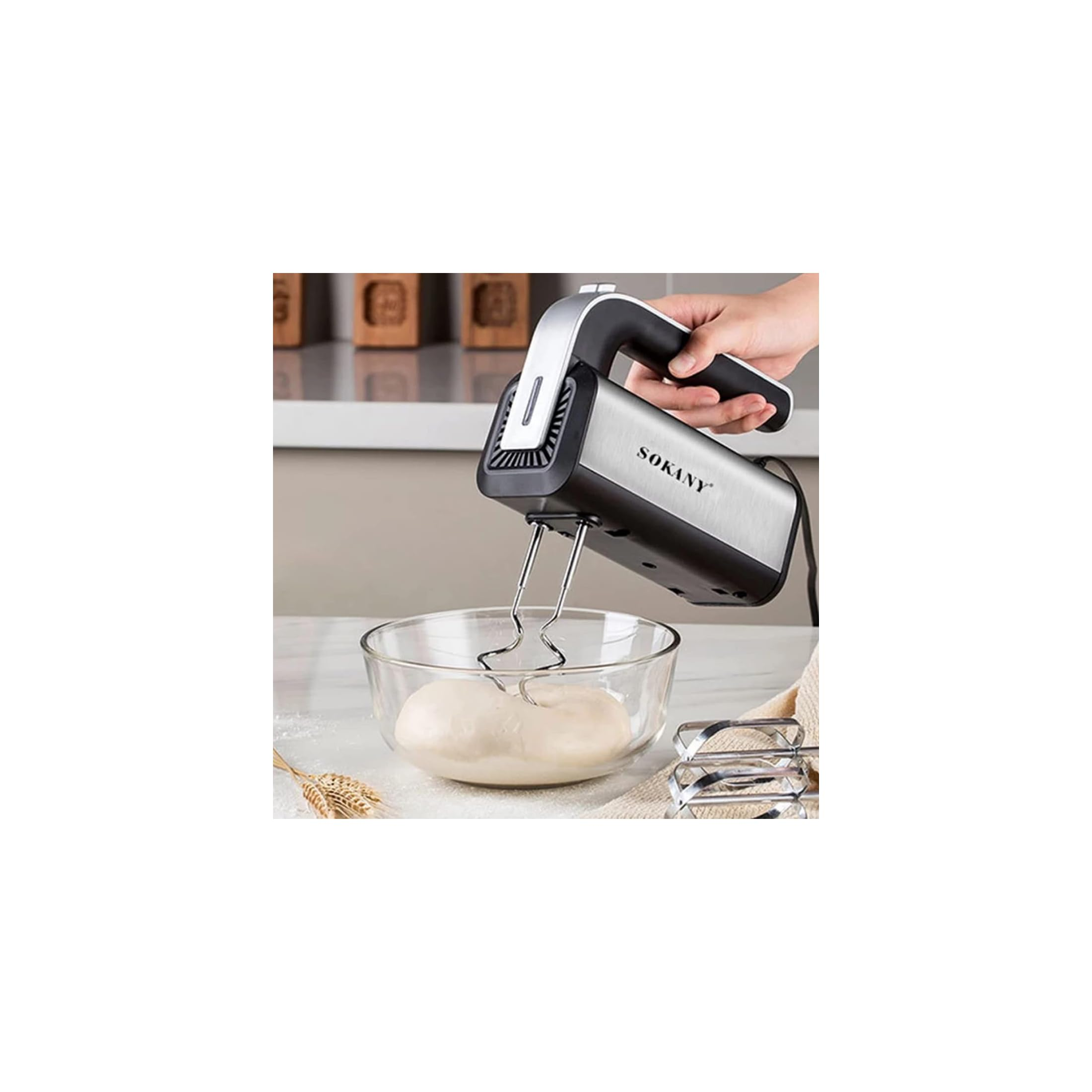 Ein silberner Handmixer mit schwarzem Griff mischt Teig in einer Glasschüssel.