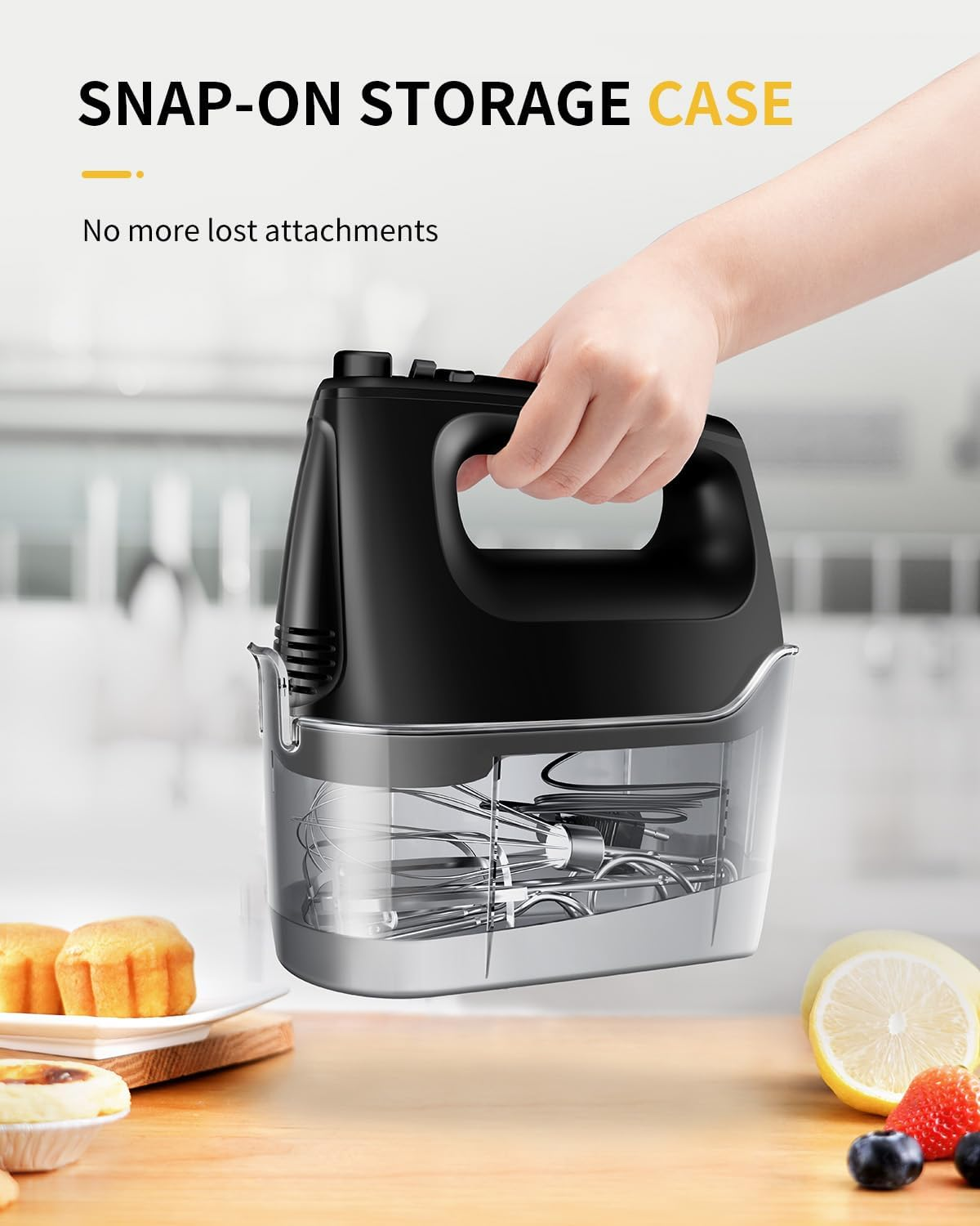 Schwarzer Handmixer mit Aufbewahrungsbehälter, Muffins und Früchten.