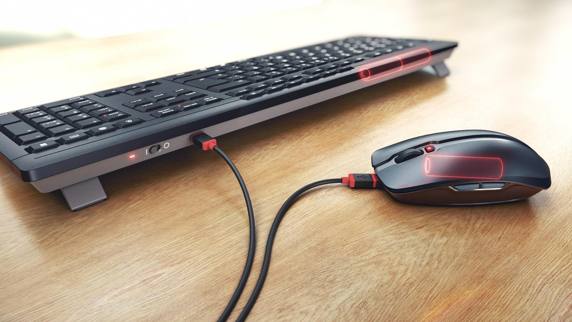 Teclado y ratón negros con indicador de carga rojo, conectados por USB.