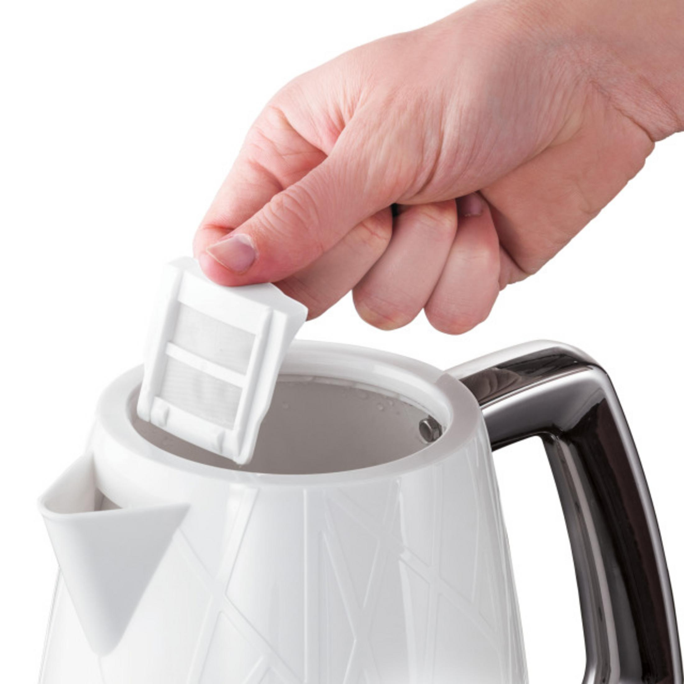 Eine Hand entfernt einen weißen Wasserfilter aus einem weißen Wasserkocher.