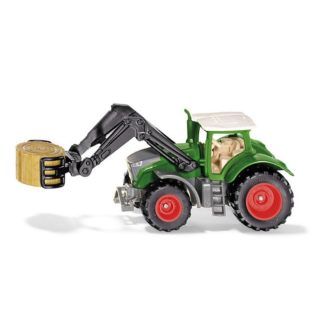 Grüner Spielzeugtraktor mit Frontlader, der einen kleinen Strohballen hält.