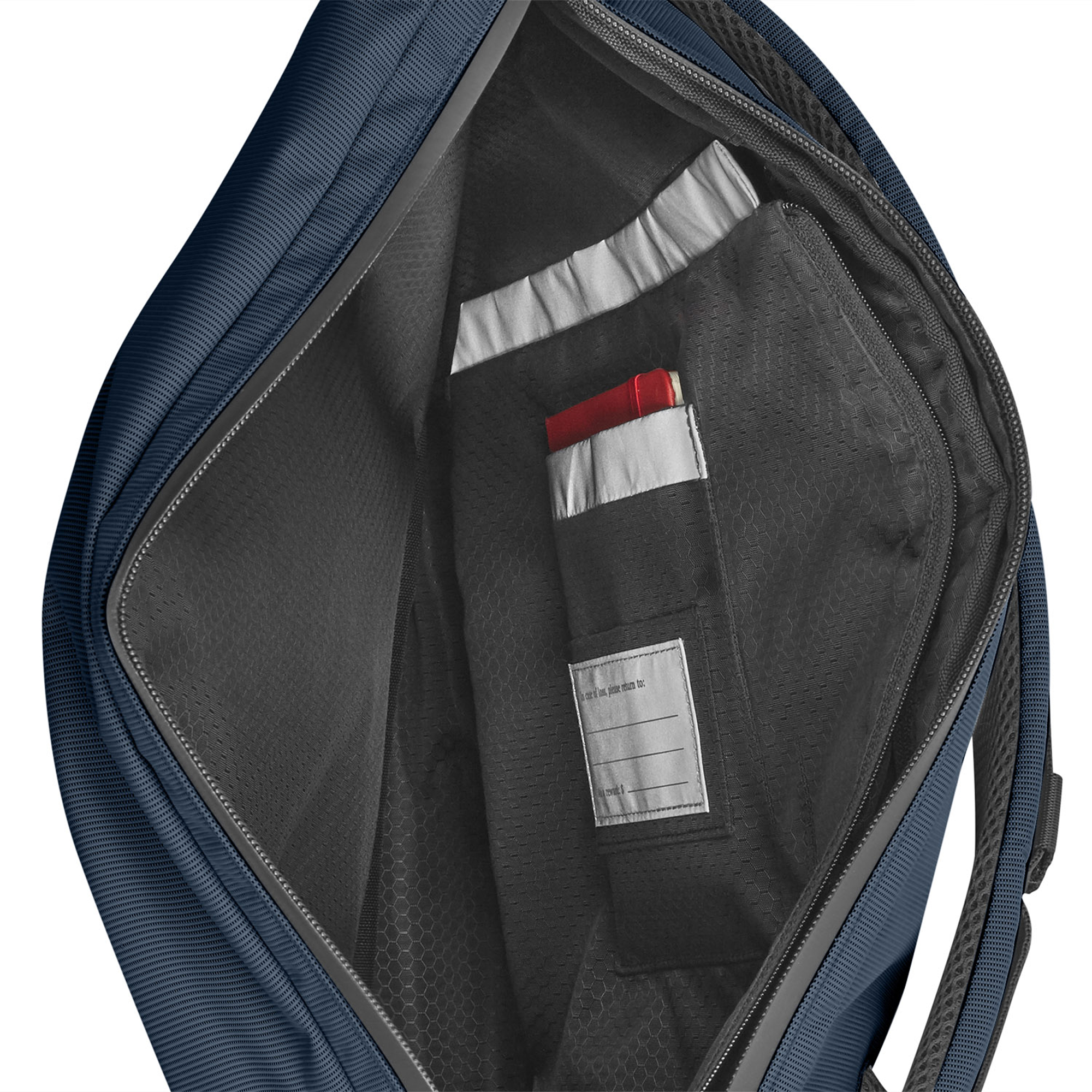 Interno zaino blu scuro con tasche a rete e un oggetto rosso.