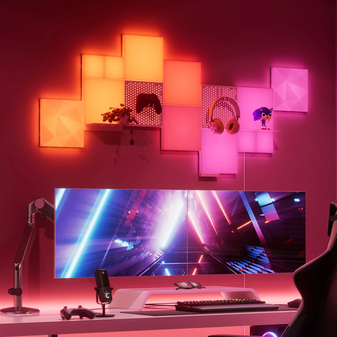 Una postazione da gioco con illuminazione RGB, monitor ultrawide e pannelli a parete.