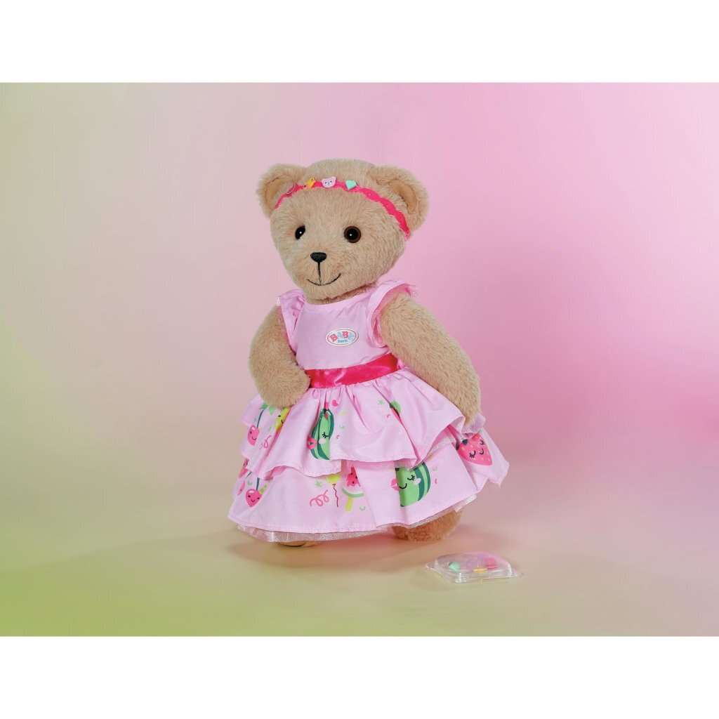 Un orsacchiotto in un vestito rosa con stampa di fragole e angurie indossa una fascia.
