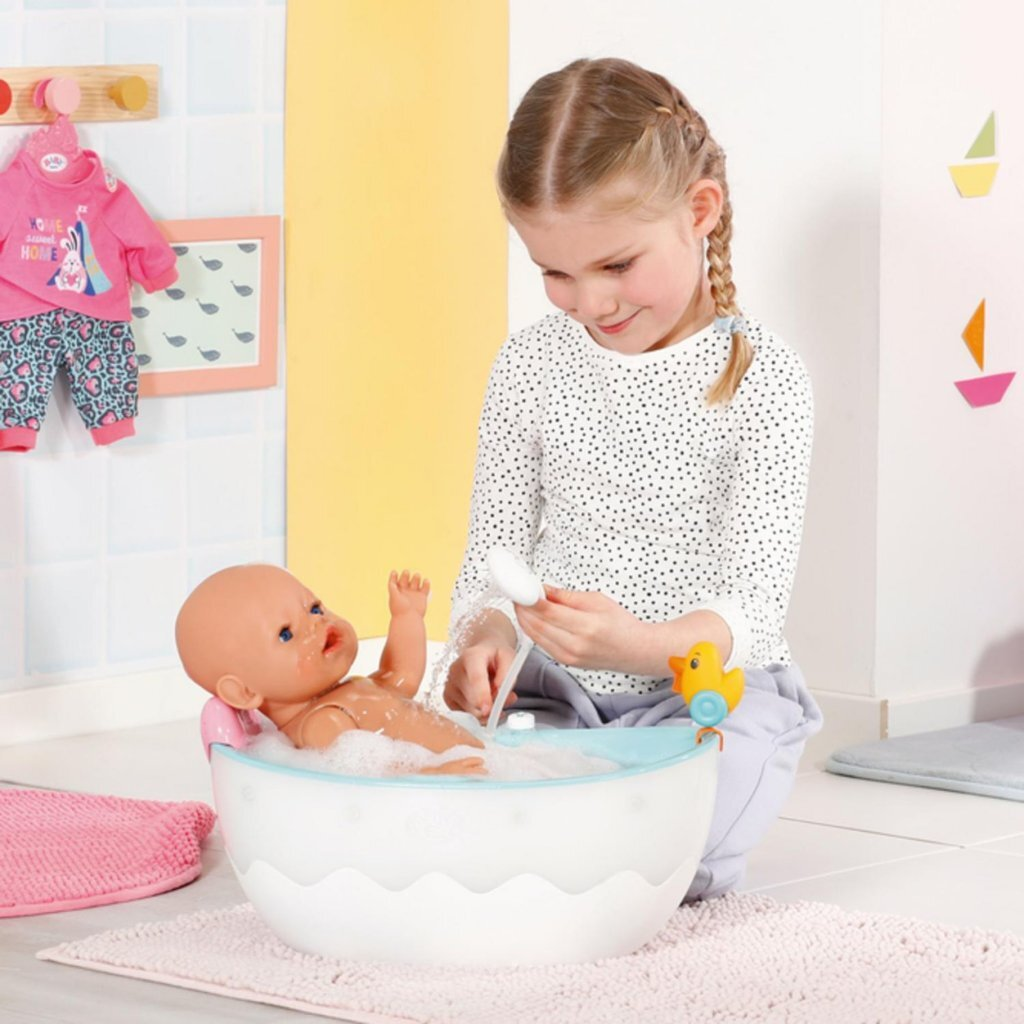 Niña lavando muñeca en una bañera azul con patito de goma.