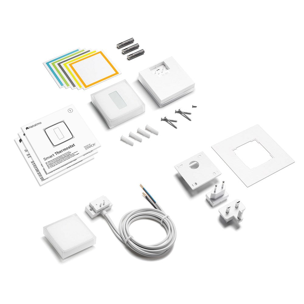Smart thermostat components: manual, mounting parts, screws, plugs, and cables.