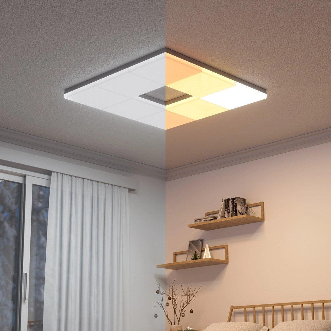 A rectangular ceiling light with white and warm illumination panels above a bed and window.