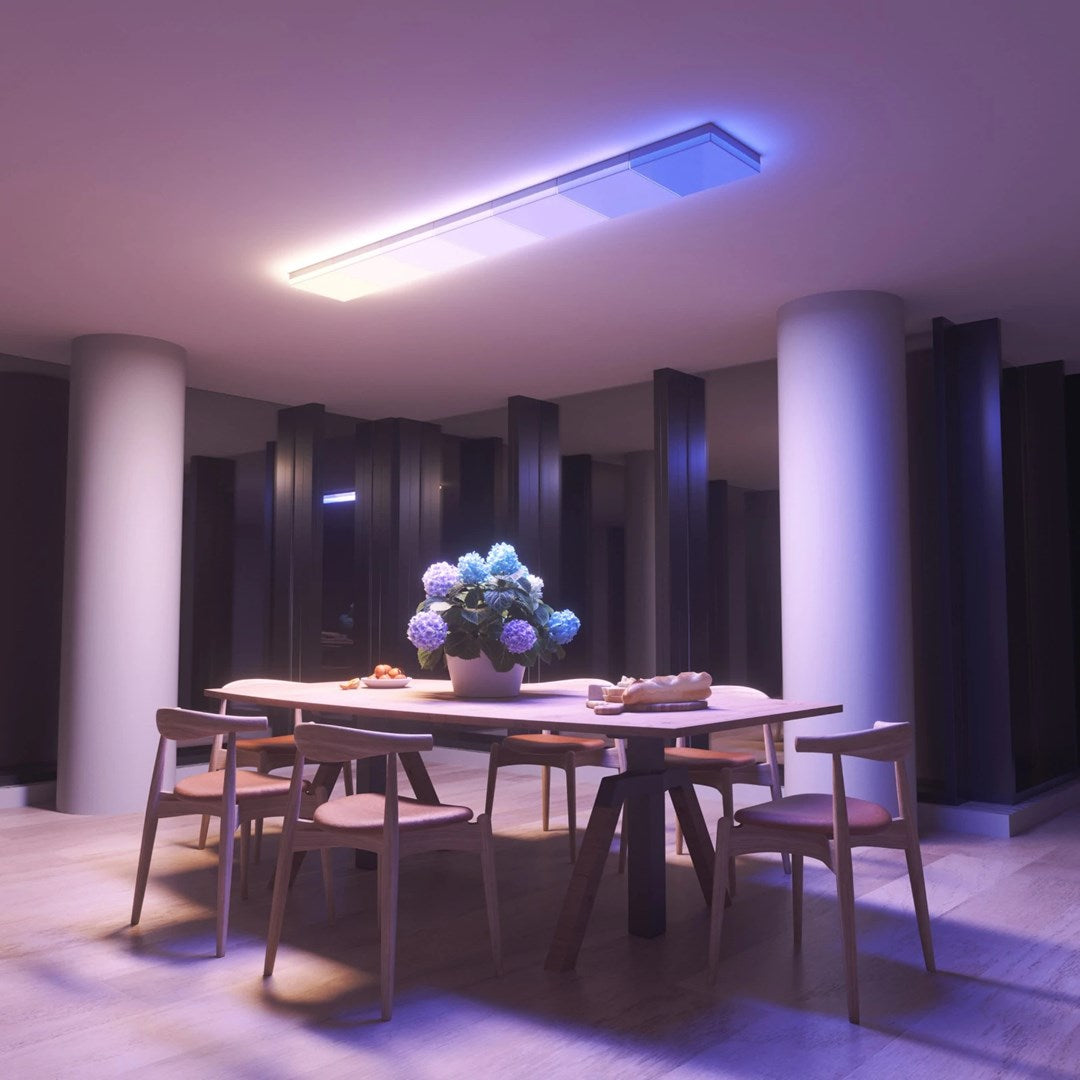 A dining table with flowers and bread, illuminated by a ceiling light.